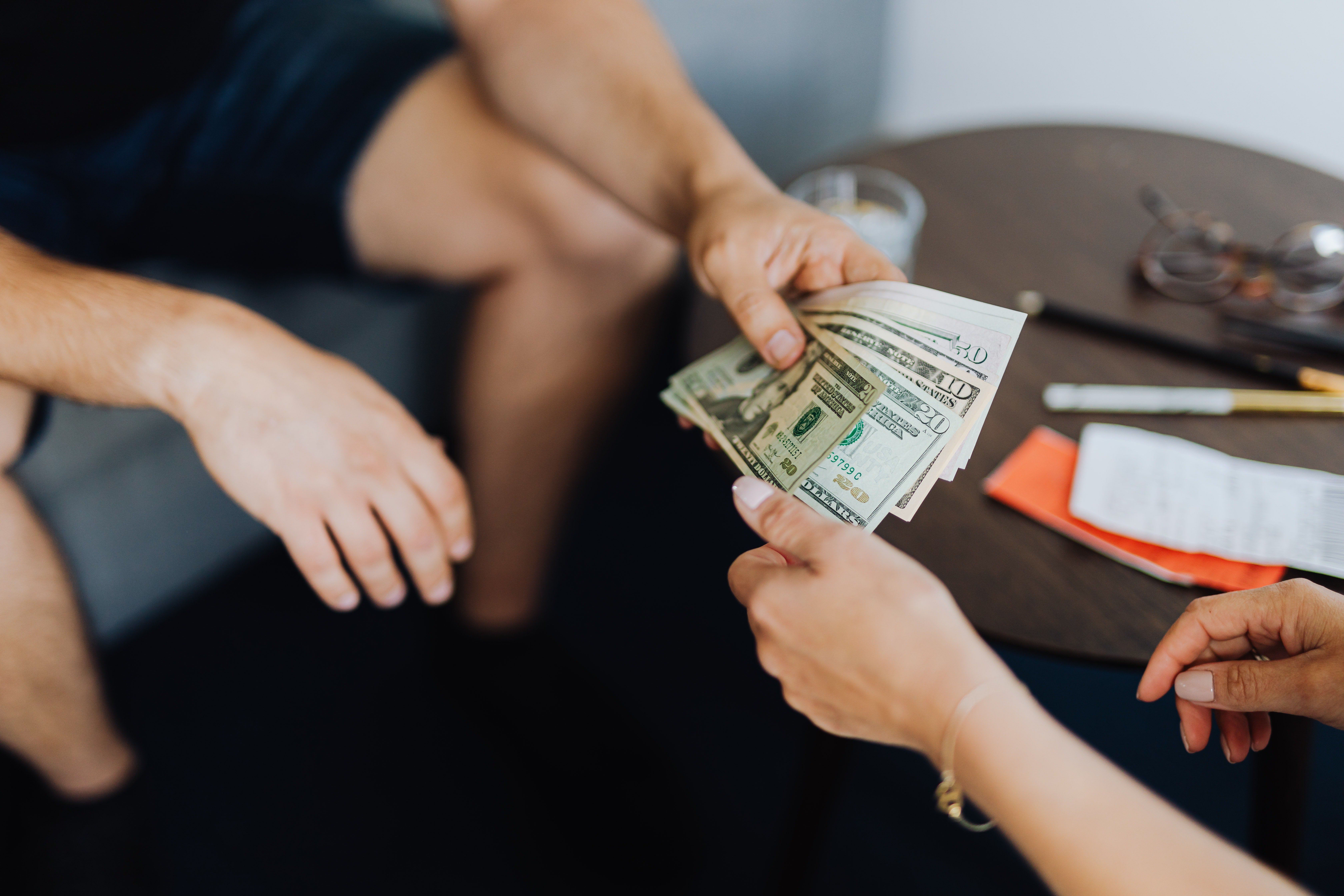 Hombre entregándole dinero a una mujer. | Foto: Pexels