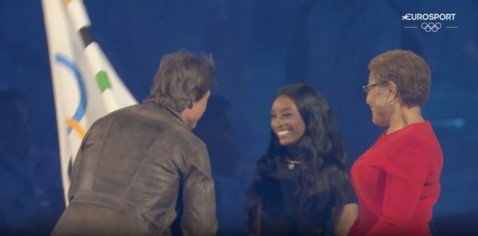 Tom Cruise arriving on the main stage to take the flag from Simone Biles and Karen Bass, posted on August 12, 2024 | Source: YouTube/Eurosport