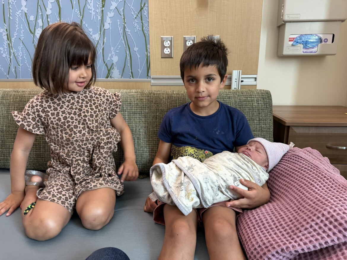The president posted the very first picture of Alec Neel Vance, being held by one of his brothers, Vivek Vance, and looked upon by his siter, Maribel Rose Vance, at the hospital. | Source: Truth Social/realDonaldTrump