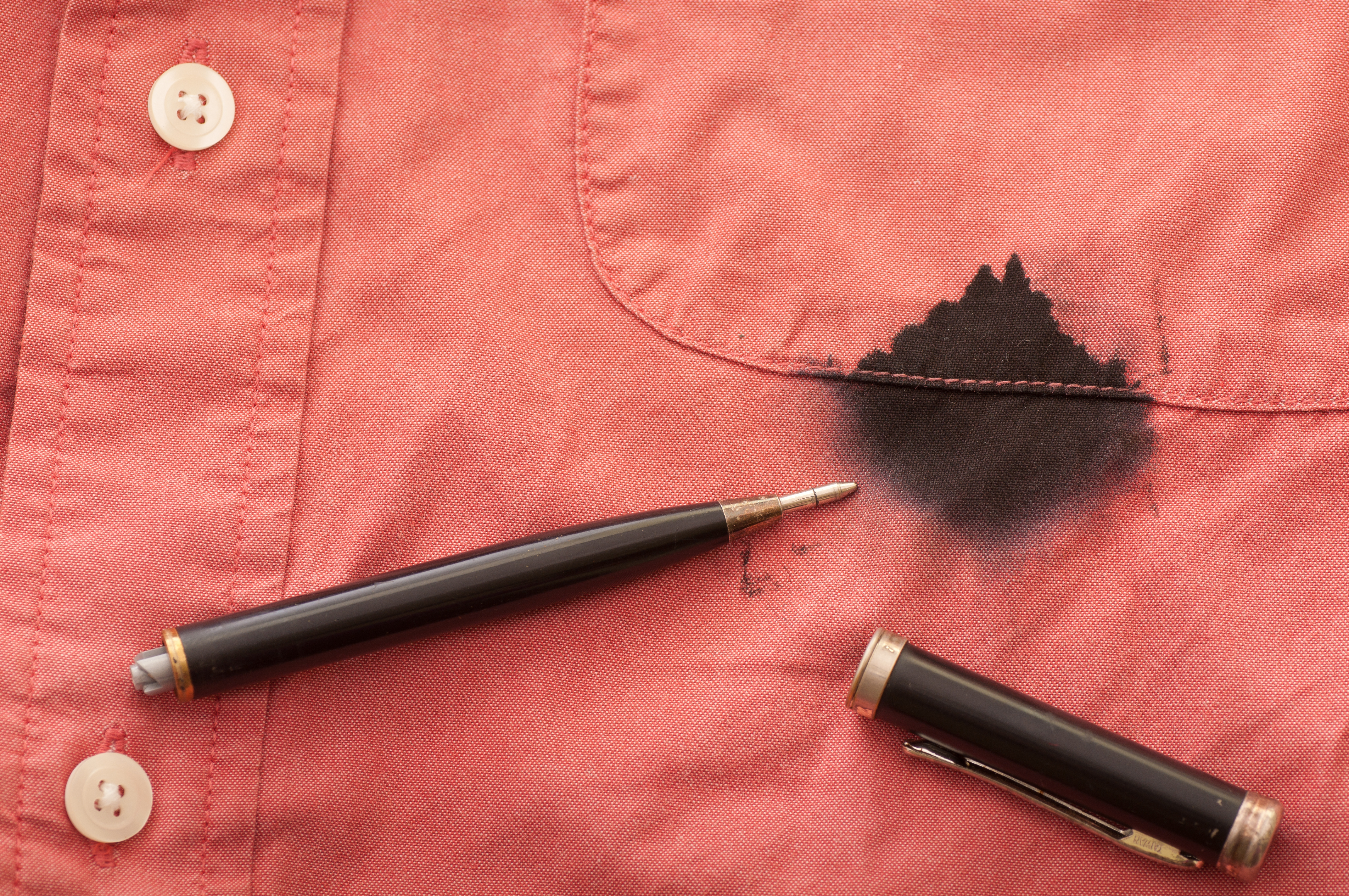 A black pen and ink stain on a salmon colored shirt | Source: Shutterstock