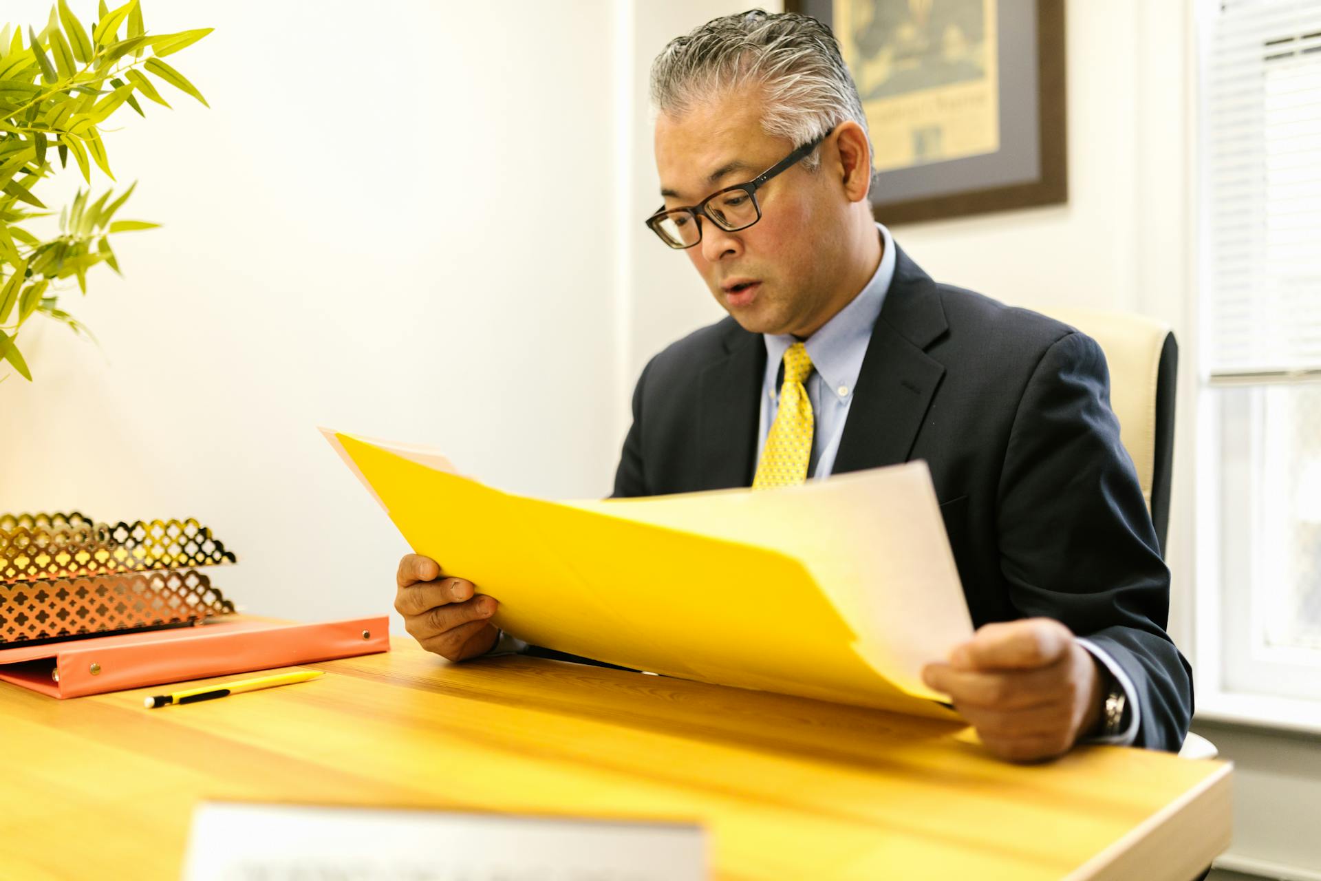 A man looking at a file in an office | Source: Pexels