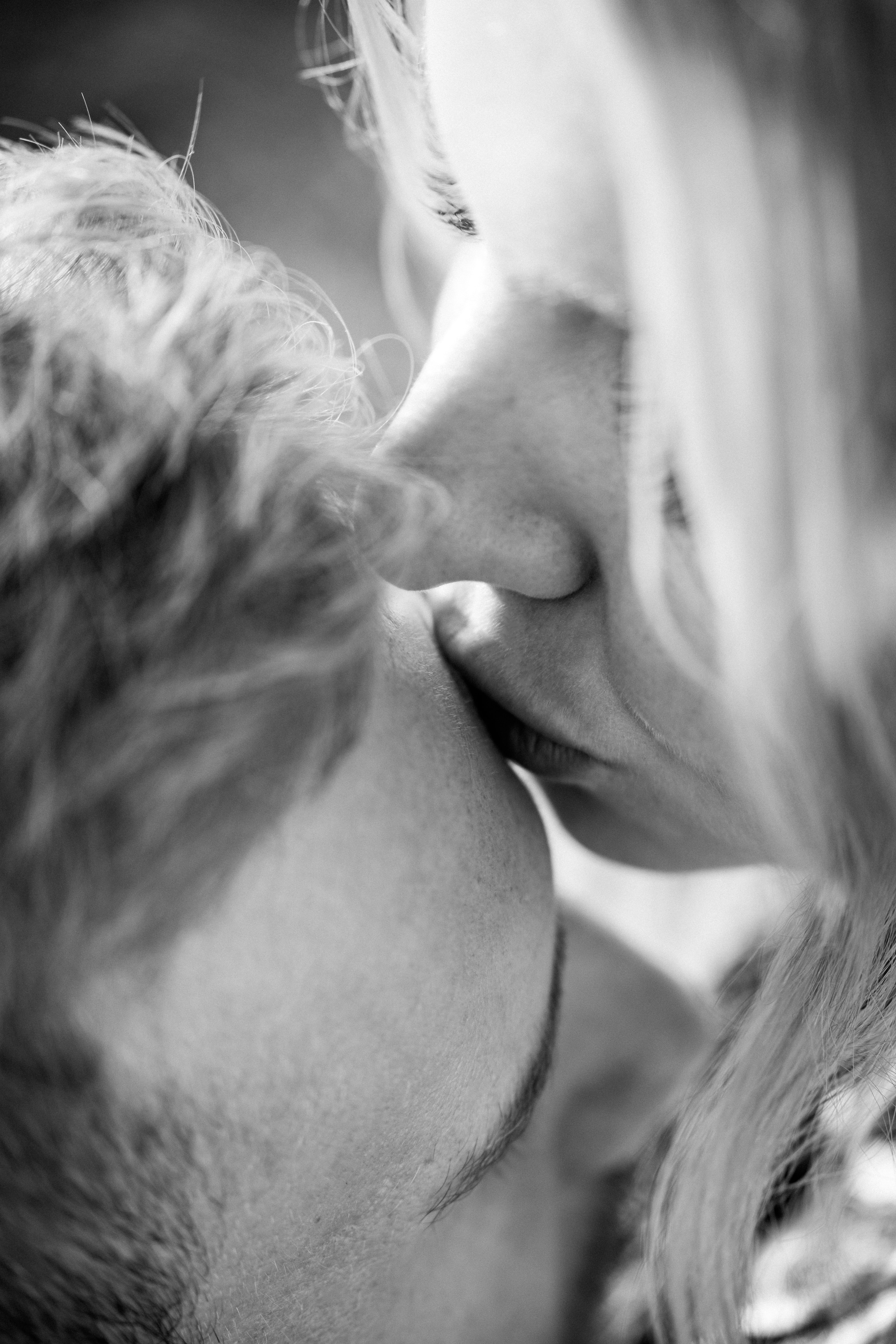Affectionate woman kissing her partner on his forehead | Source: Unsplash