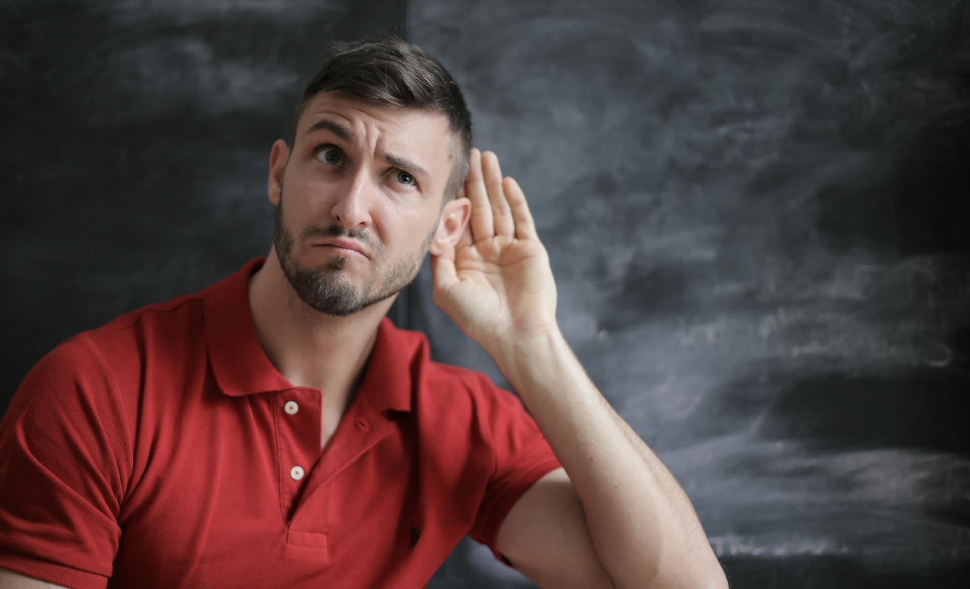 A man cupping his ear to listen | Source: Pexels