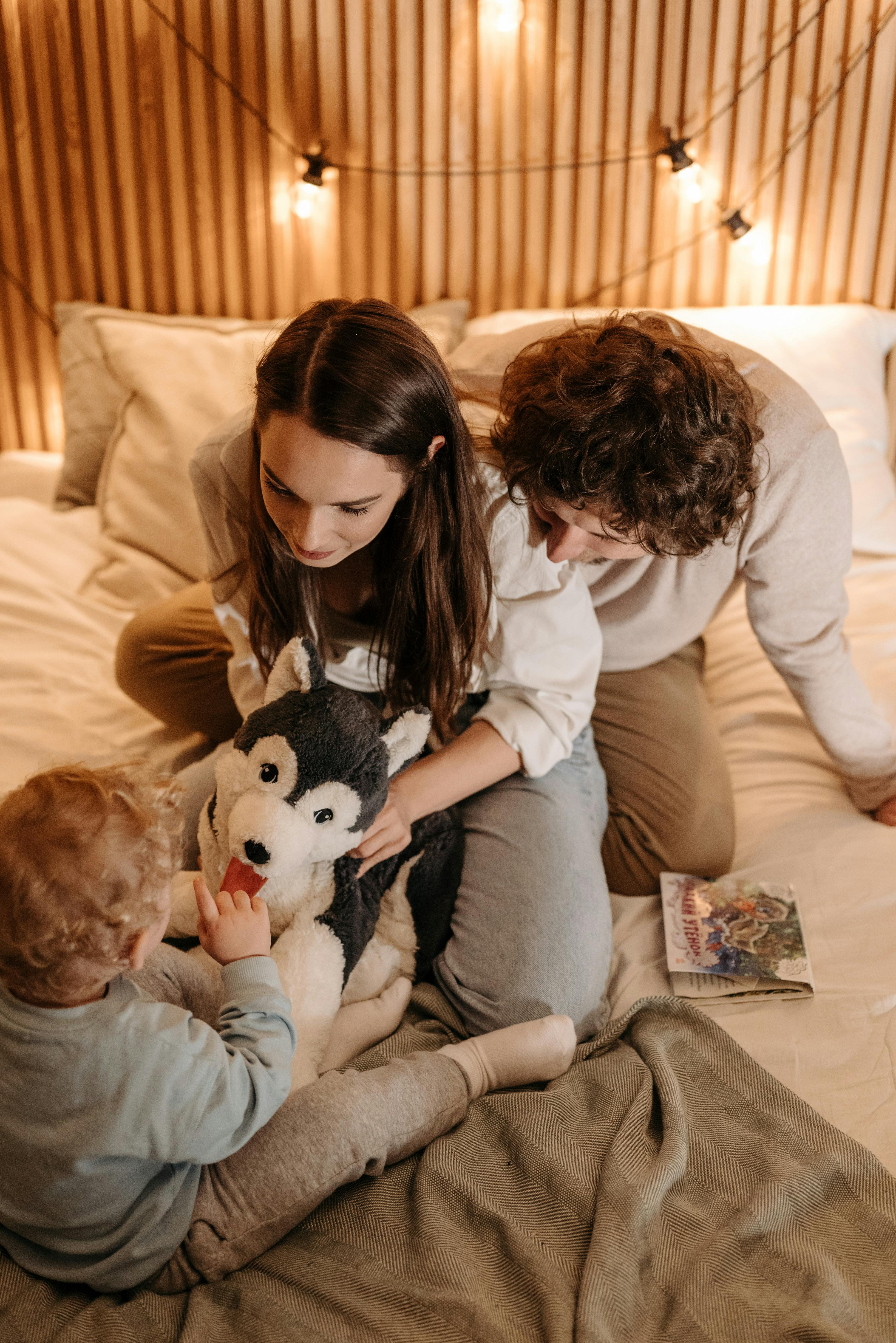 A happy couple playing with a child | Source: Pexels
