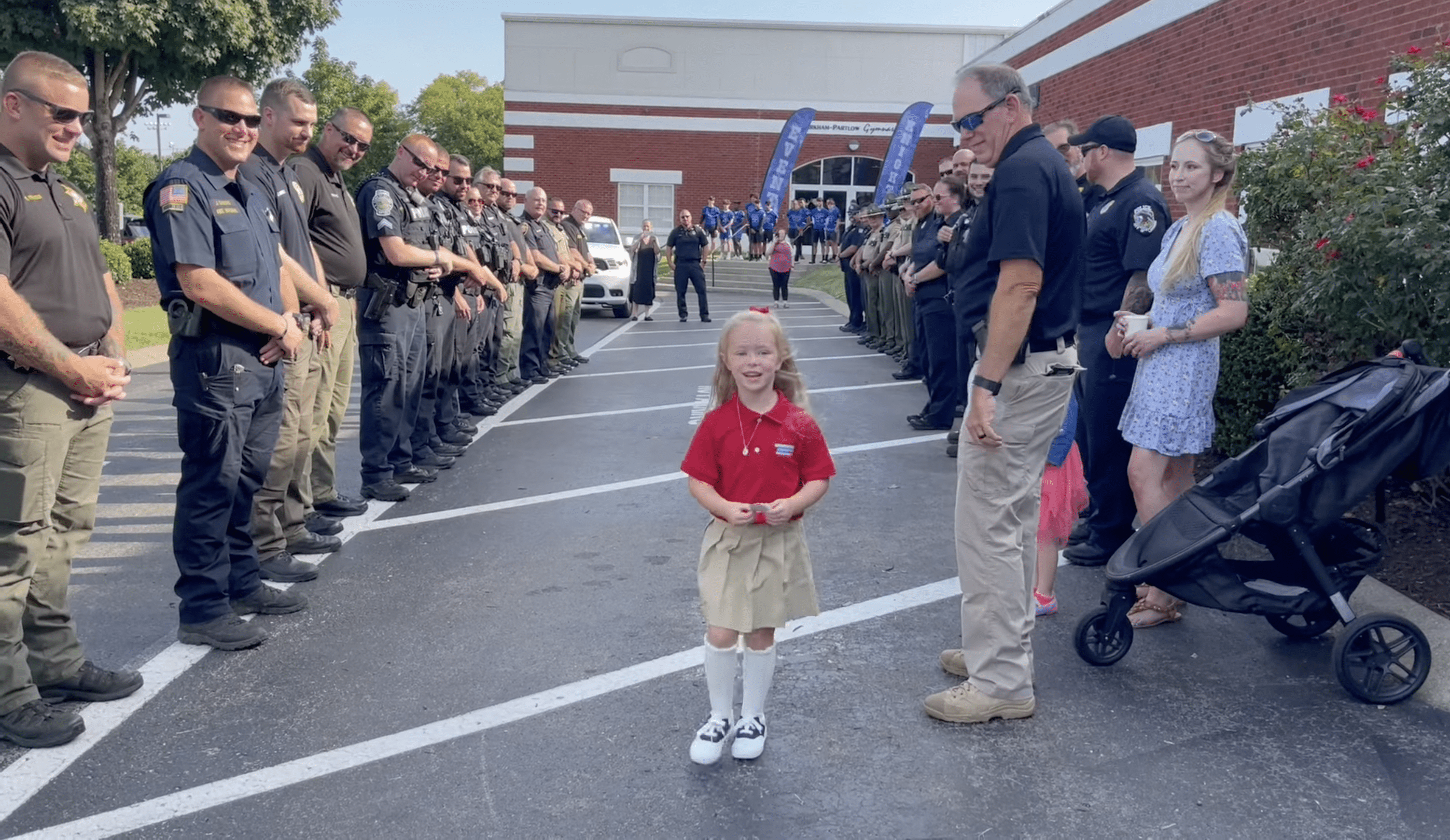 Cops lining both sides of a parking lot with Anna walking in the middle. | Source: Facebook.com/La Vergne Police Department