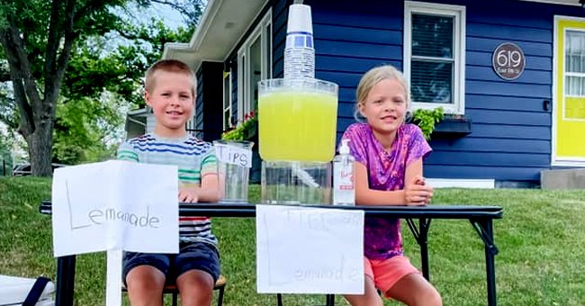 Twins sit and smile at their lemonade stand despite thief that stole all of their tips | Photo: Facebook/karensmidt