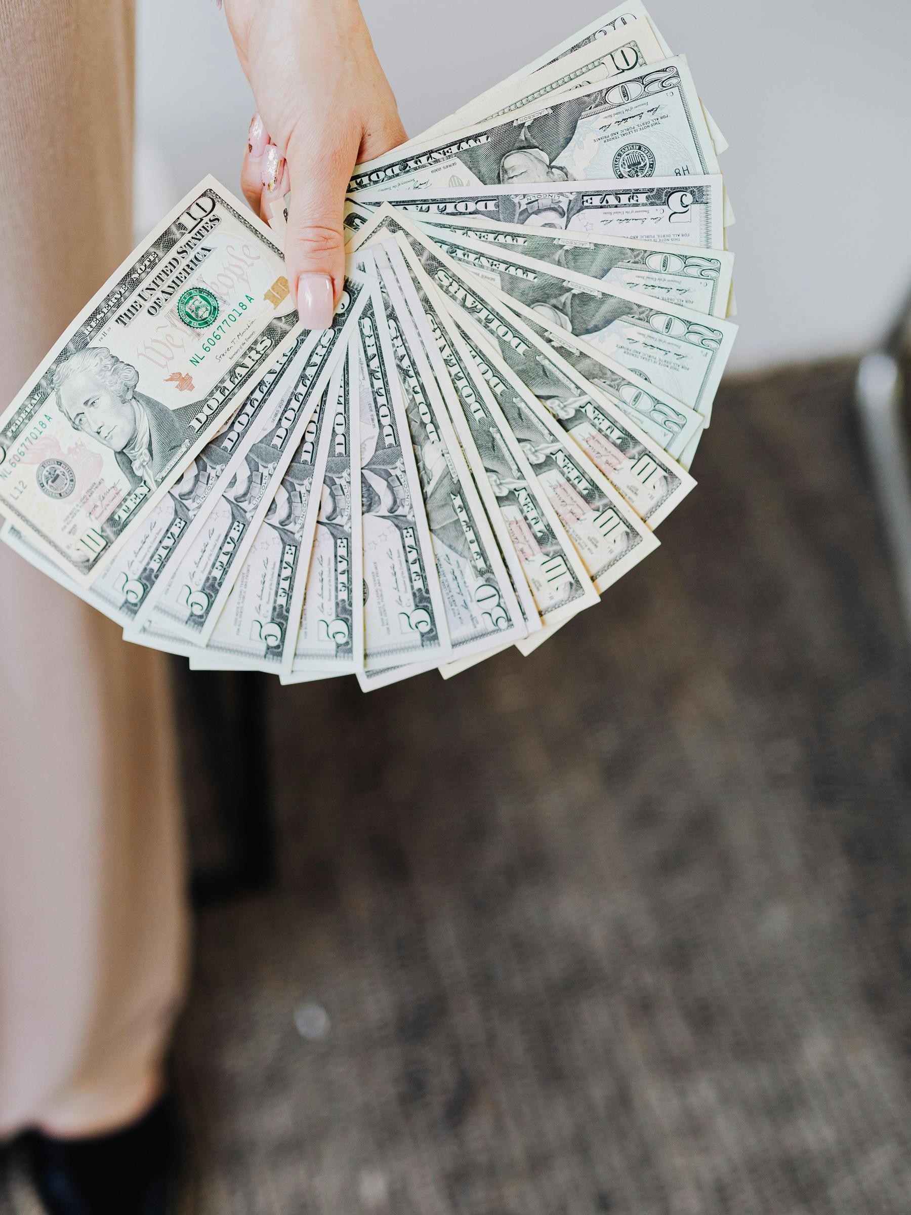 The woman secretly places a wad of cash under a seat, planning her next move | Source: Pexels