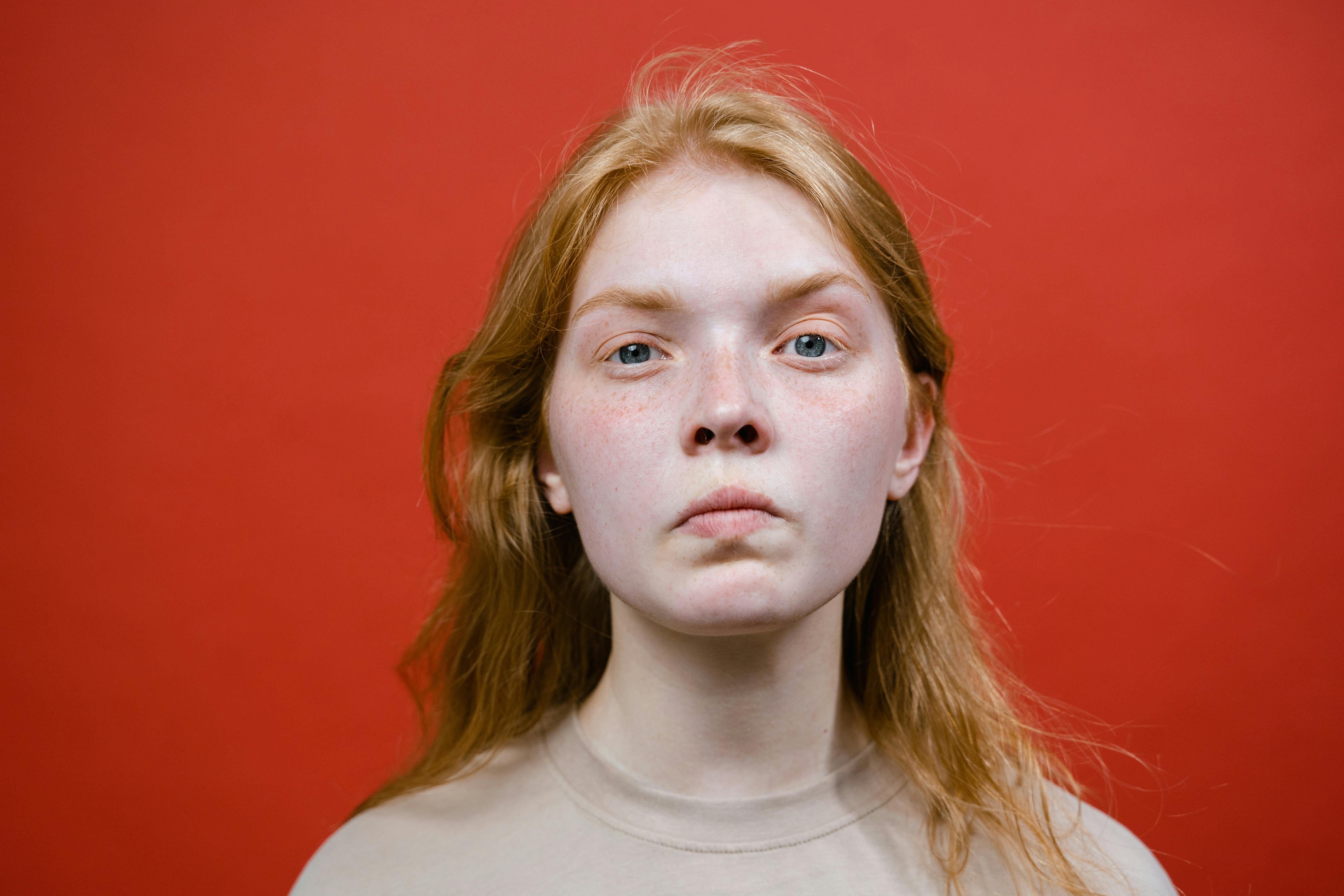 An angry young woman on red backdrop | Source: Pexels