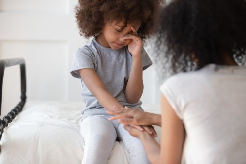 Niña triste es consolada por una mujer adulta. | Foto: Shutterstock