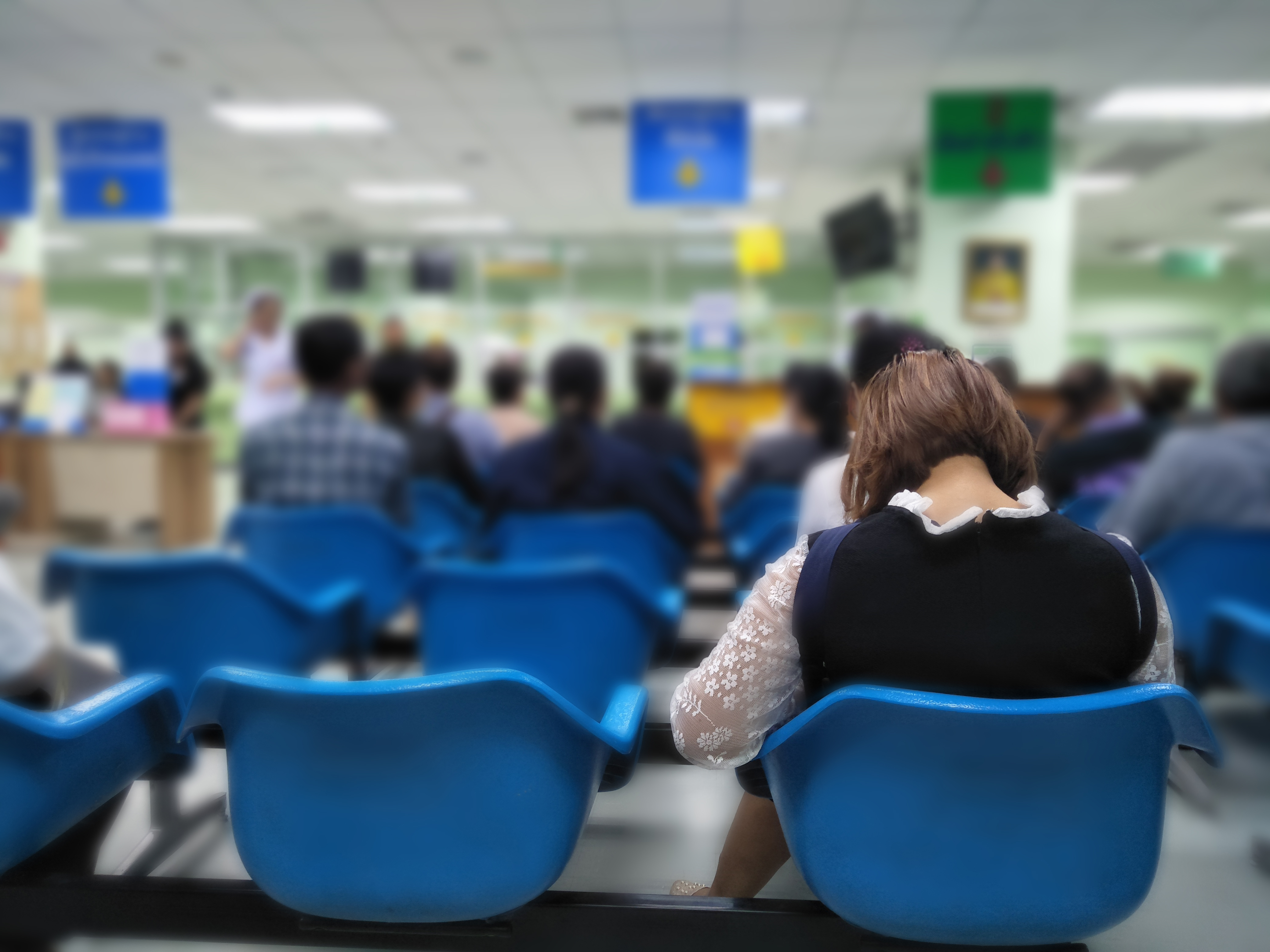 Woman and many people waiting in the hospital. | Source: Shutterstock