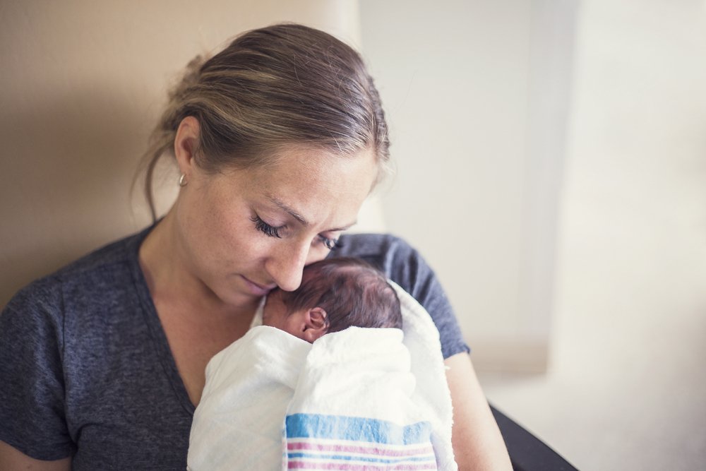 Mujer sostiene en brazos a un bebé. | Foto: Shutterstock
