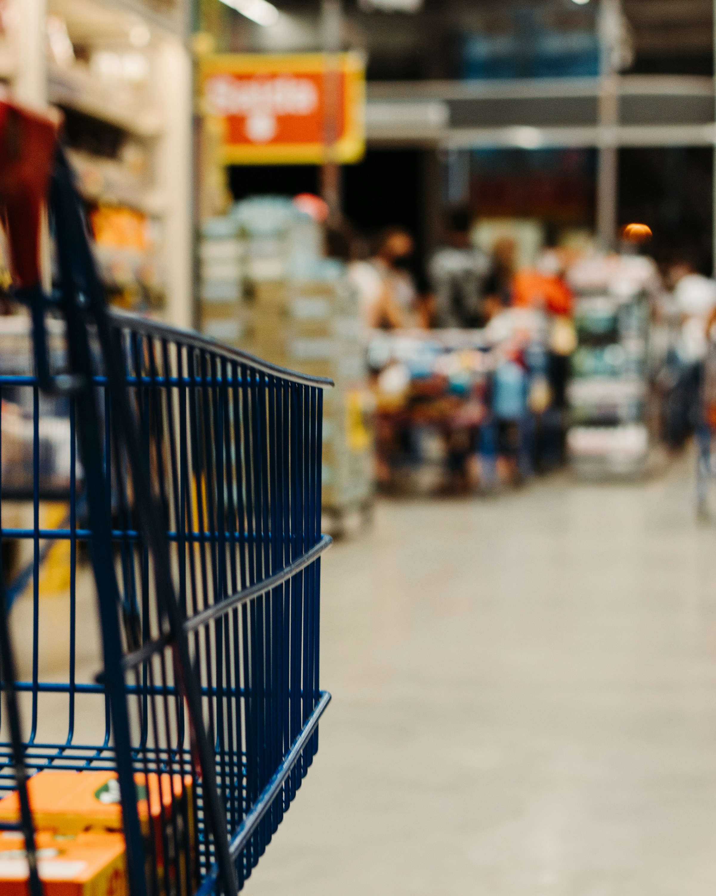 A shopping cart in a grocery store aisle | Source: Unsplash