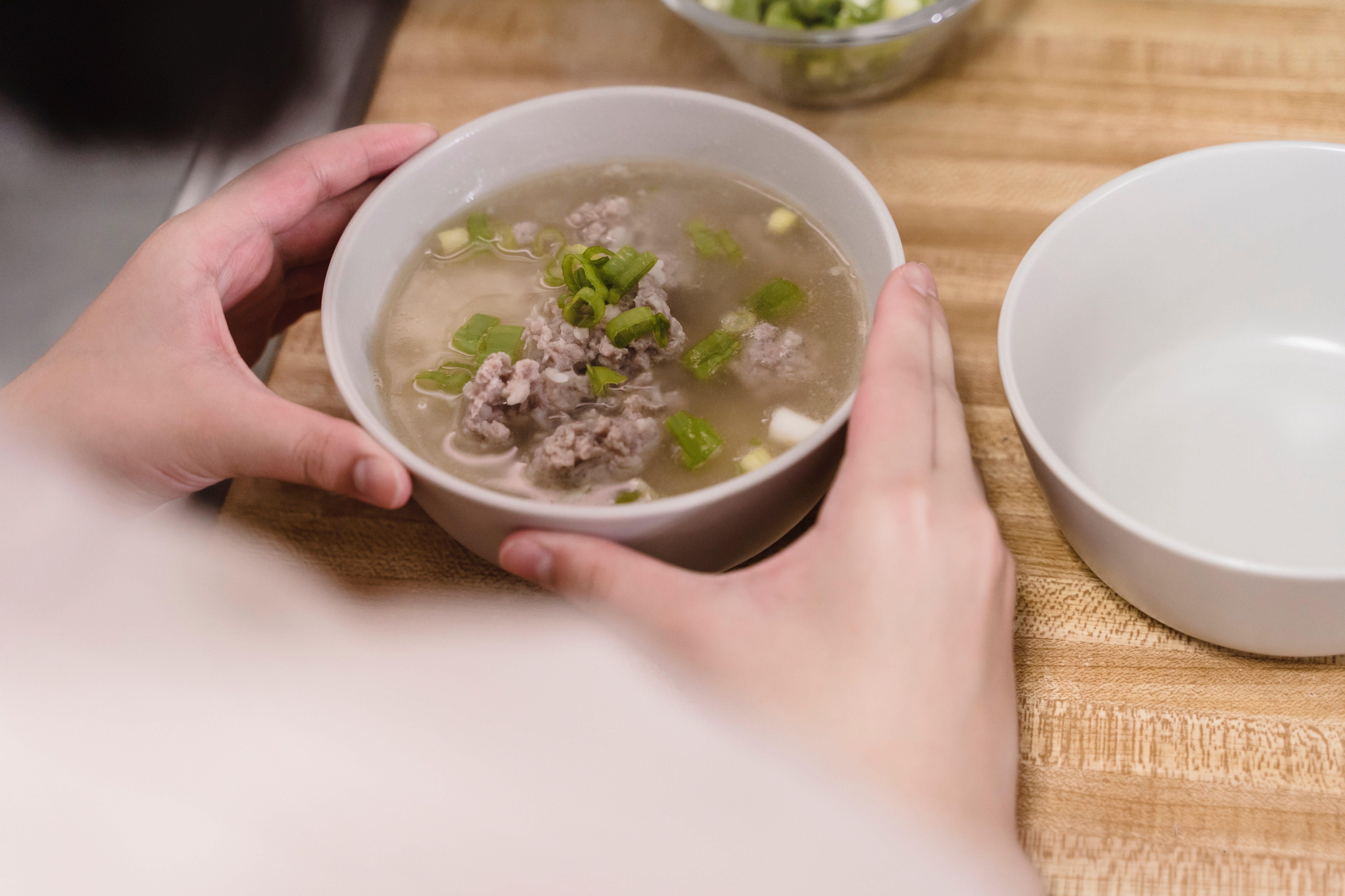 Dos manos sostienen un plato de sopa. | Foto: Pexels