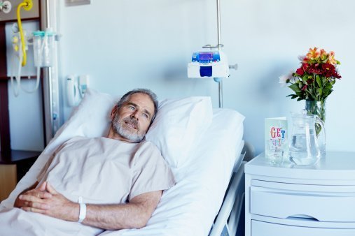 Man relaxing on bed in hospital ward | Photo: Getty Images