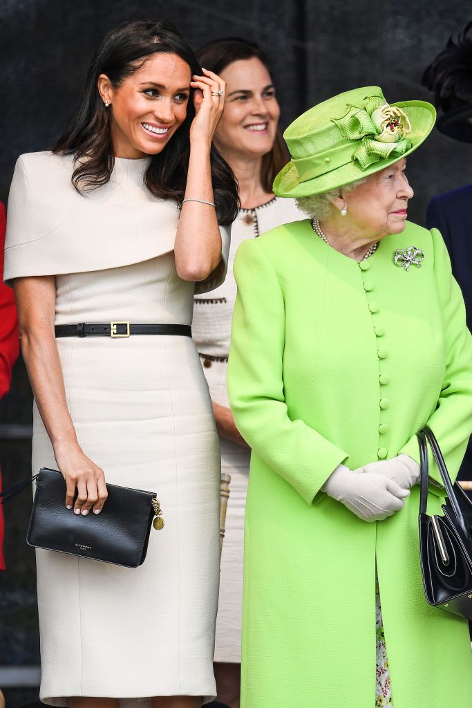  Queen Elizabeth II stands with Meghan, Duchess of Sussex accompanied by Samantha Cohen during a ceremony to open the new Mersey Gateway Bridge | Getty Images 