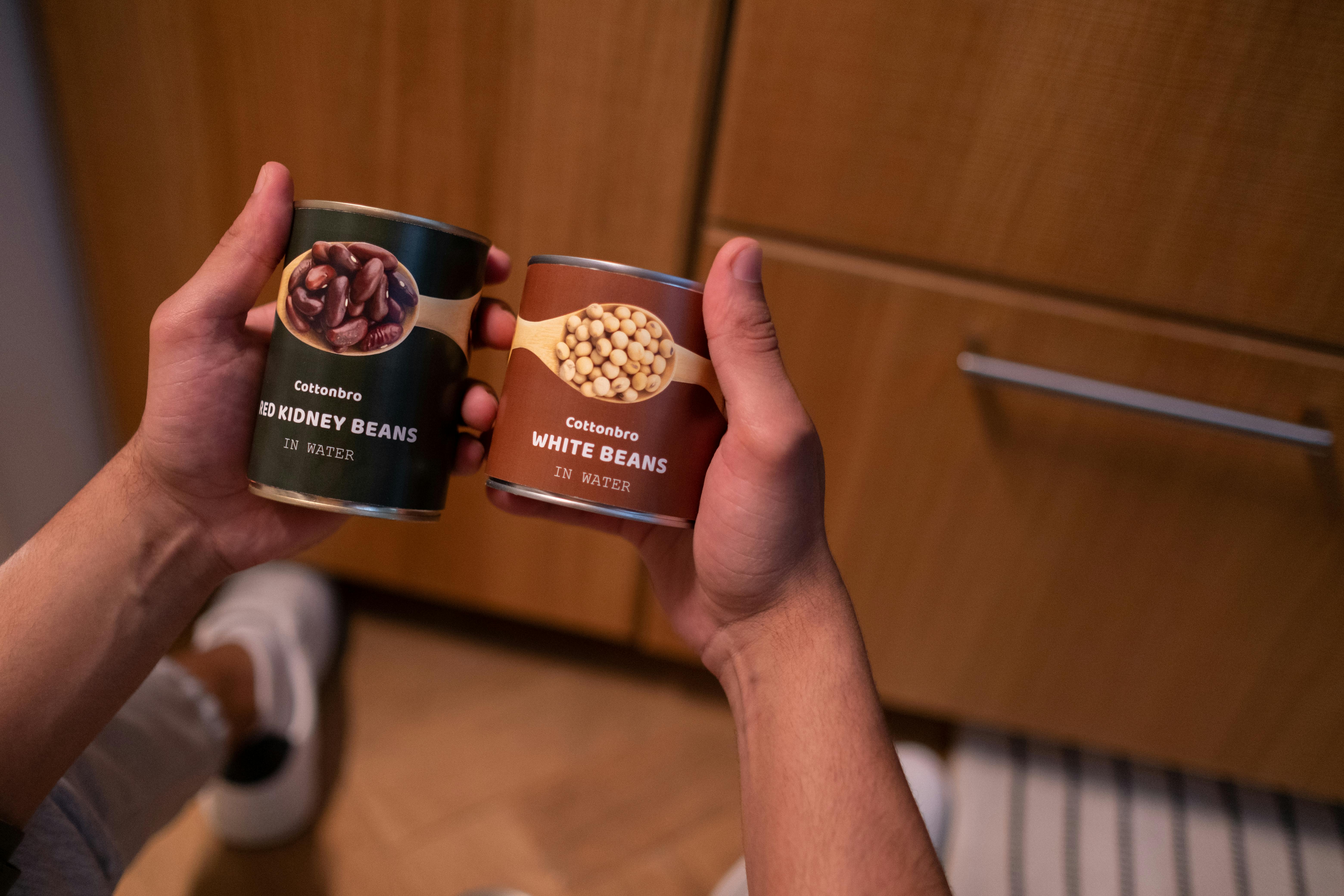 Hands holding cans of beans | Source: Pexels