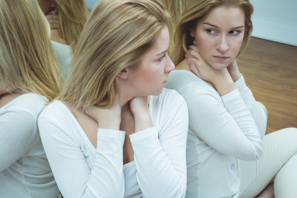 Mujer deprimida mirándose en el espejo. | Foto: Shutterstock