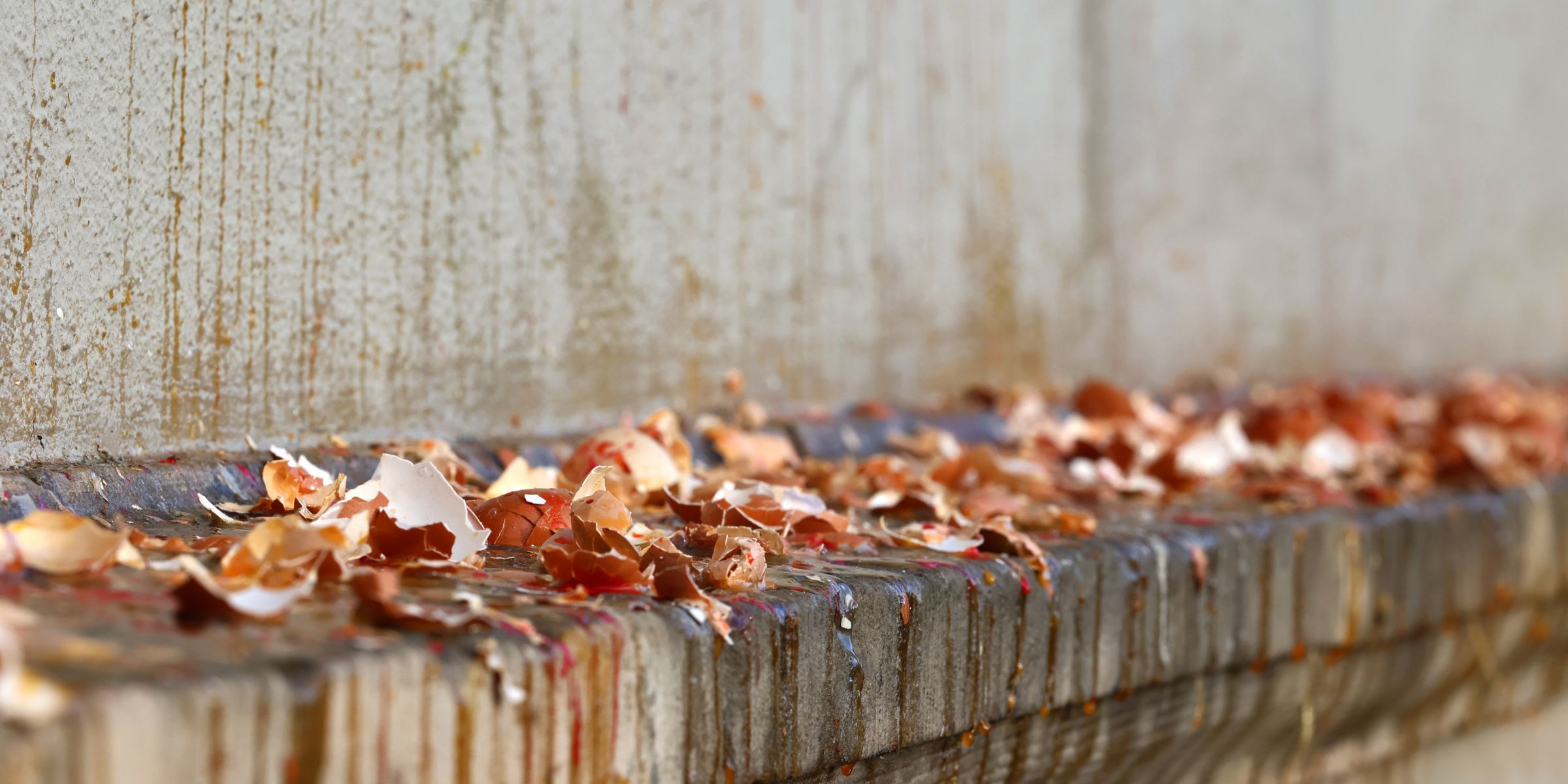 Shells of broken eggs on the wall of the building | Source: Shutterstock