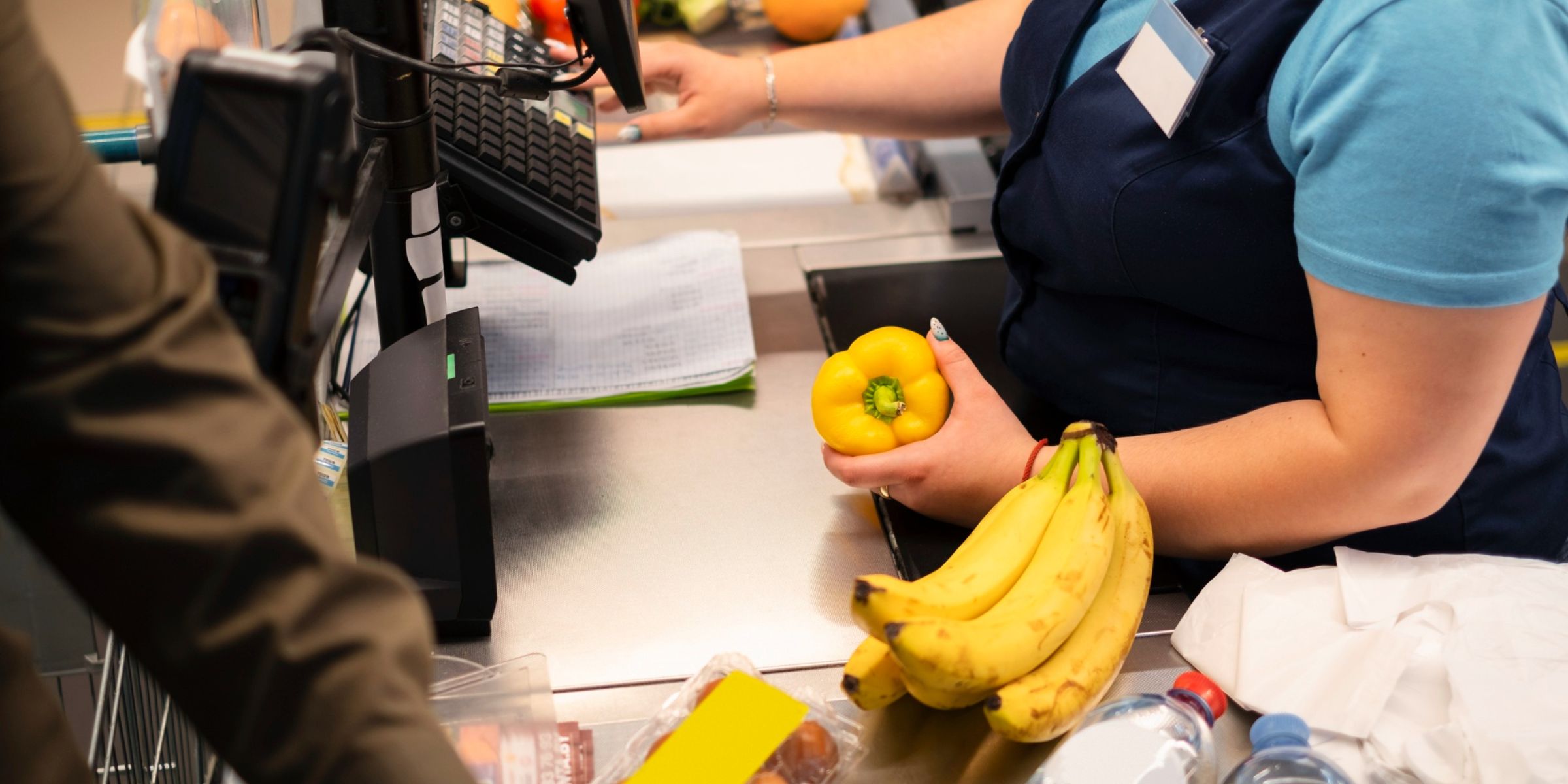 A grocery store cashier ringing up items | Source: Freepik