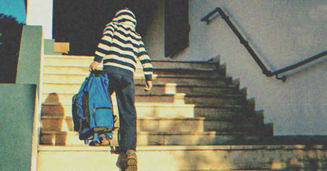 Joven subiendo las escaleras de la escuela cargando un bolso. | Foto: Shutterstock