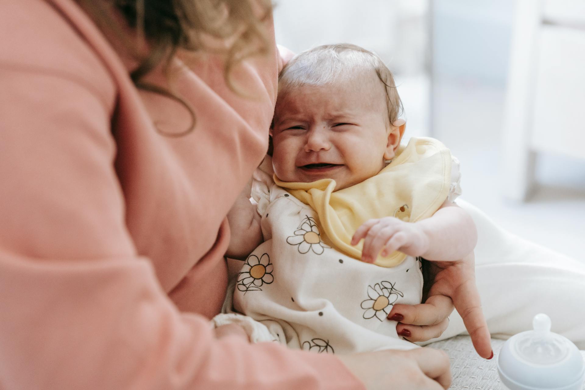 A woman holding a crying baby | Source: Pexels