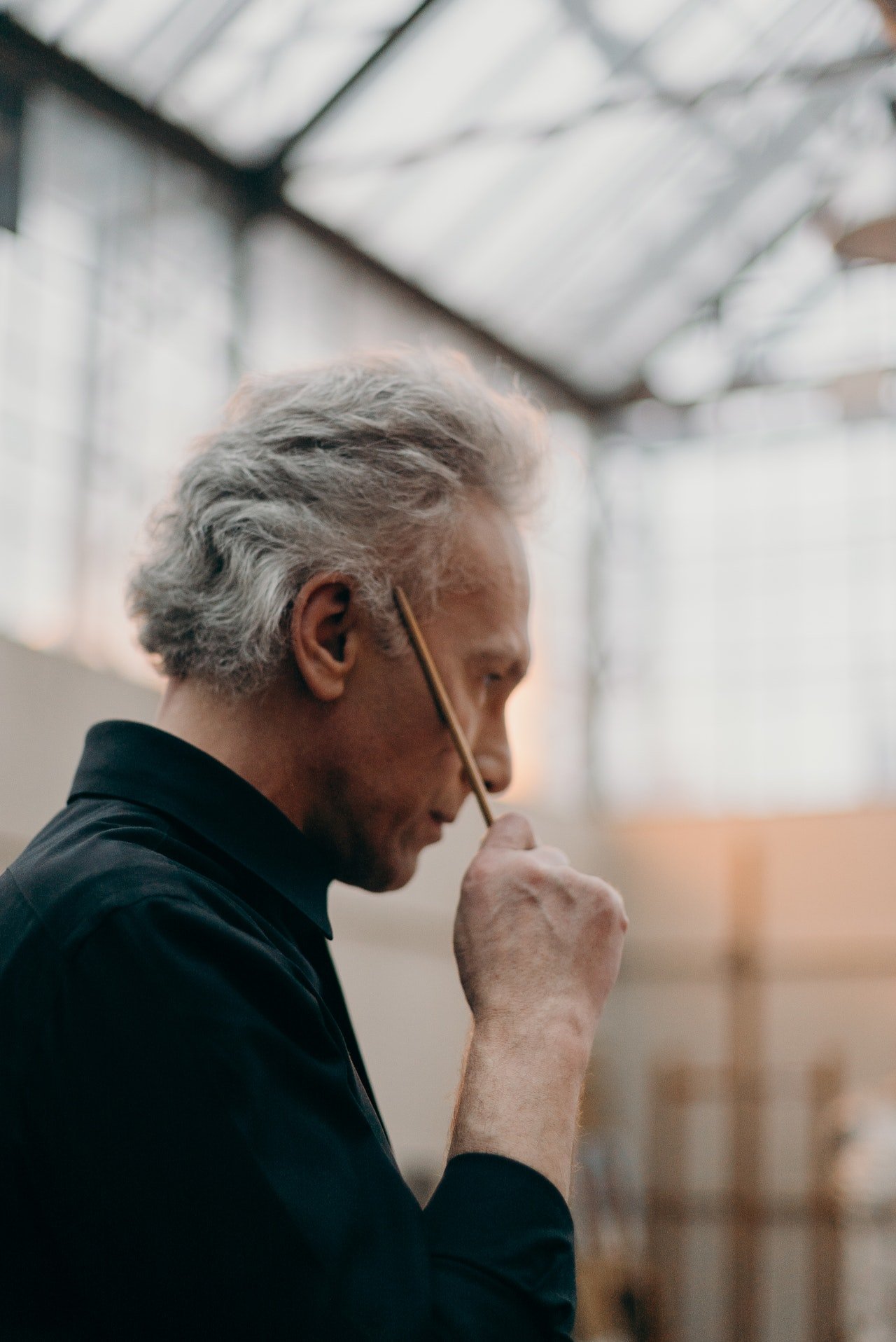 Hombre con un lápiz apoyado en su sien. | Foto: Pexels