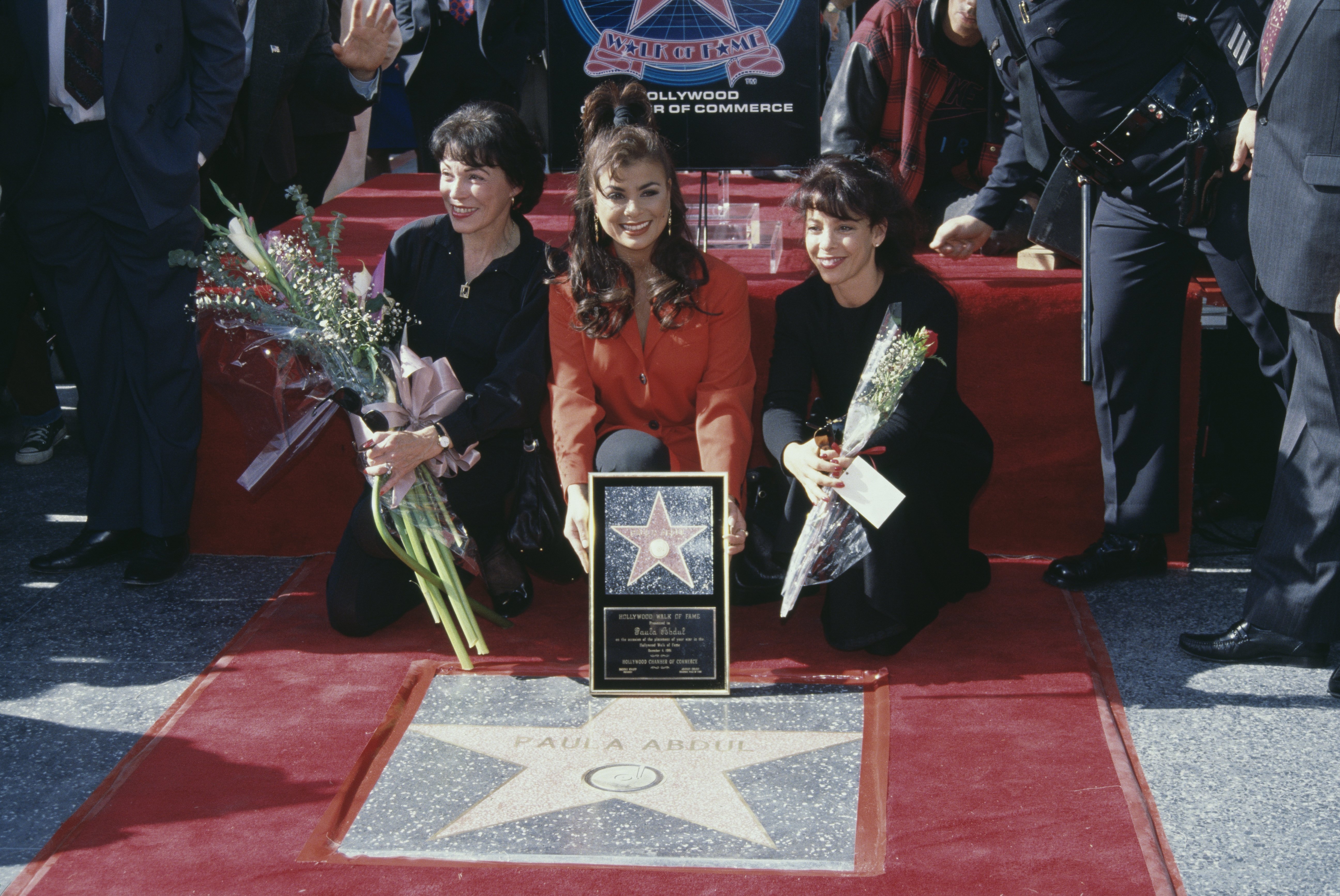 American singer and dancer Paula Abdul (centre), with her mother, Canadian pianist Lorraine Rykiss, and sister, Wendy Mandel, during Abdul's Hollywood Walk of Fame Star Ceremony, held at 7021 Hollywood Boulevard, in Los Angeles, California, in December 4, 1991. | Source: Getty Images
