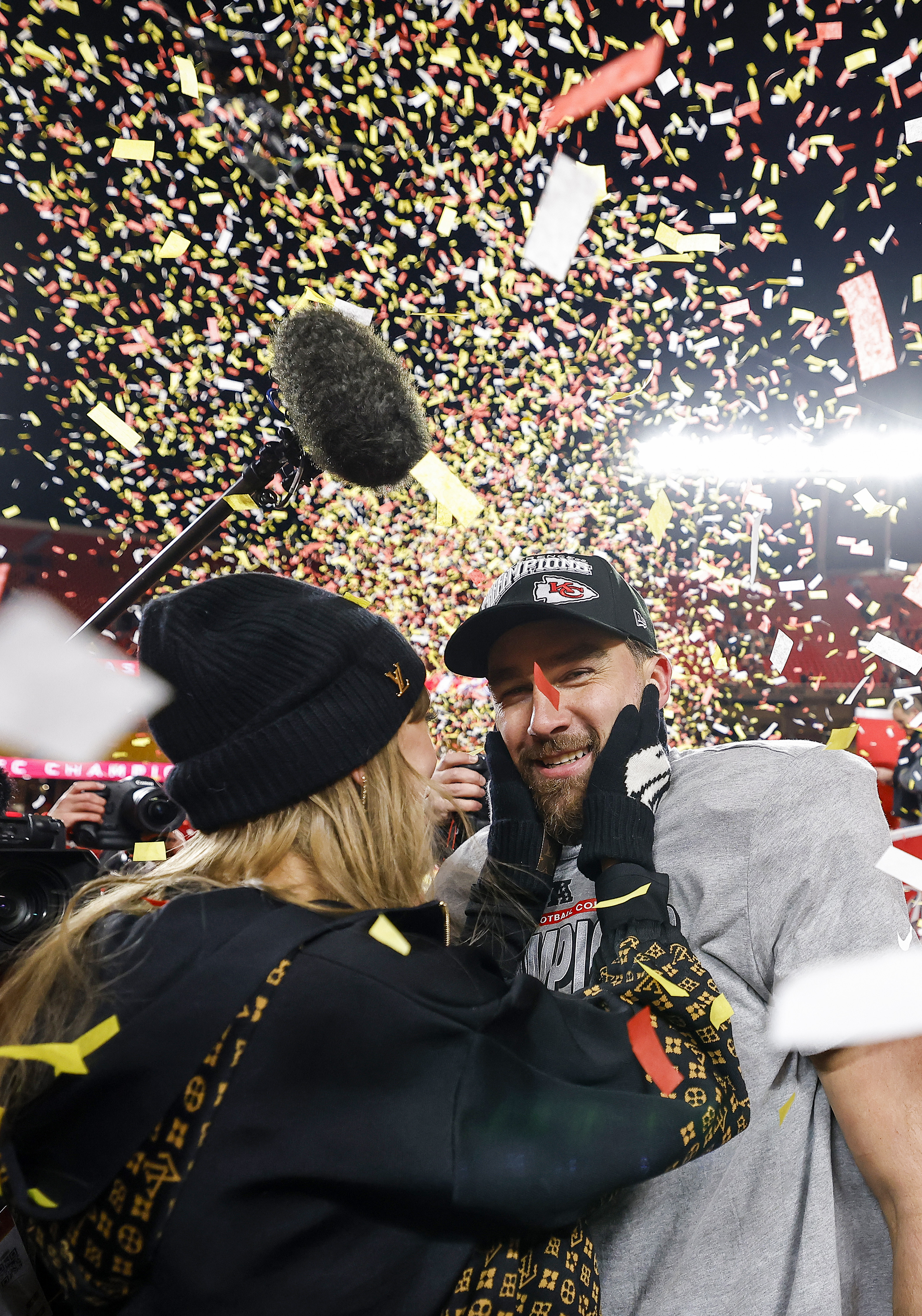 Taylor Swift cups the face of Travis Kelce #87 of the Kansas City Chiefs with both hands as confetti rains down, celebrating the team's 32-29 victory over the Buffalo Bills in the AFC Championship Game at GEHA Field at Arrowhead Stadium on January 26, 2025, in Missouri.