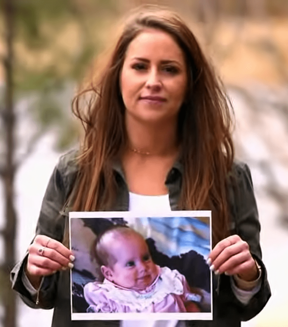 Andrea Klug-Napier holding her baby picture. | Source: youtube.com/ABC News