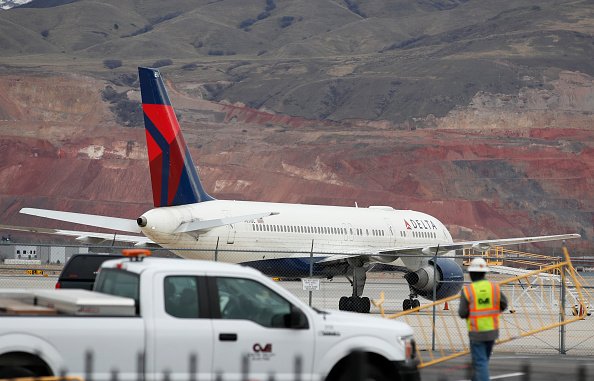  A worker sets up barriers as a Delta plane sits idle at the Salt Lake International Airport after it was closed due to an earthquake on March 18, 2020 in Salt Lake City, Utah | Photo: Getty Images