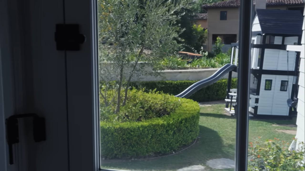 Leo's bedroom window offers a perfect view of a massive backyard playground and slide. | Source: YouTube/@Archdigest