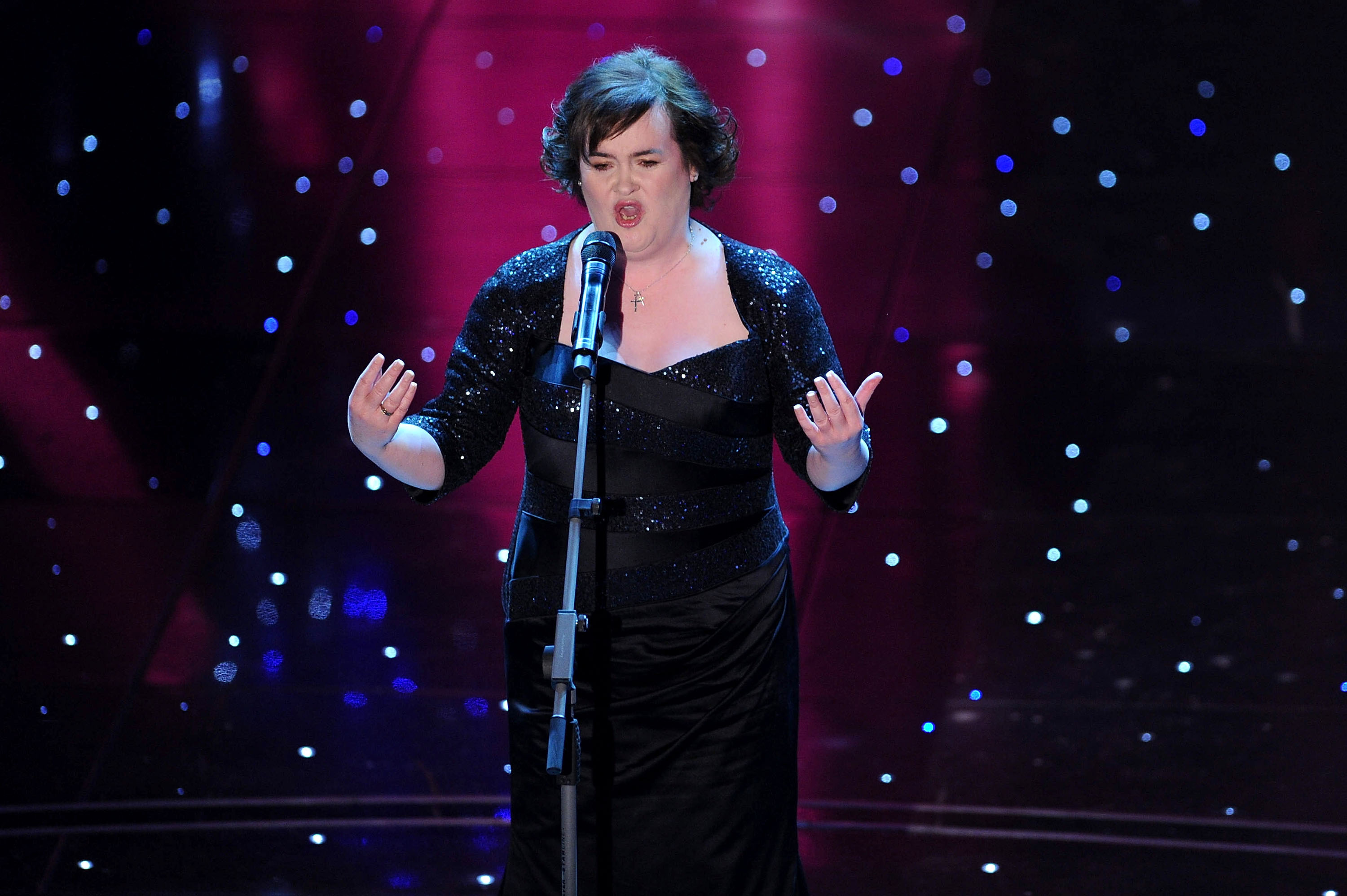 Boyle commands the stage at the Ariston Theatre in San Remo, Italy, on 16 February 2010, arms outstretched in a floor-length black gown and sequinned jacket as she performs at the 60th Sanremo Song Festival