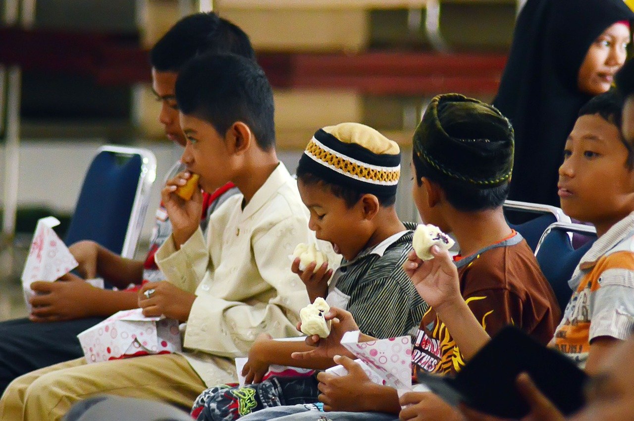 A group of different aged children eating lunch together | Photo: Pixabay/Saiful Mulia