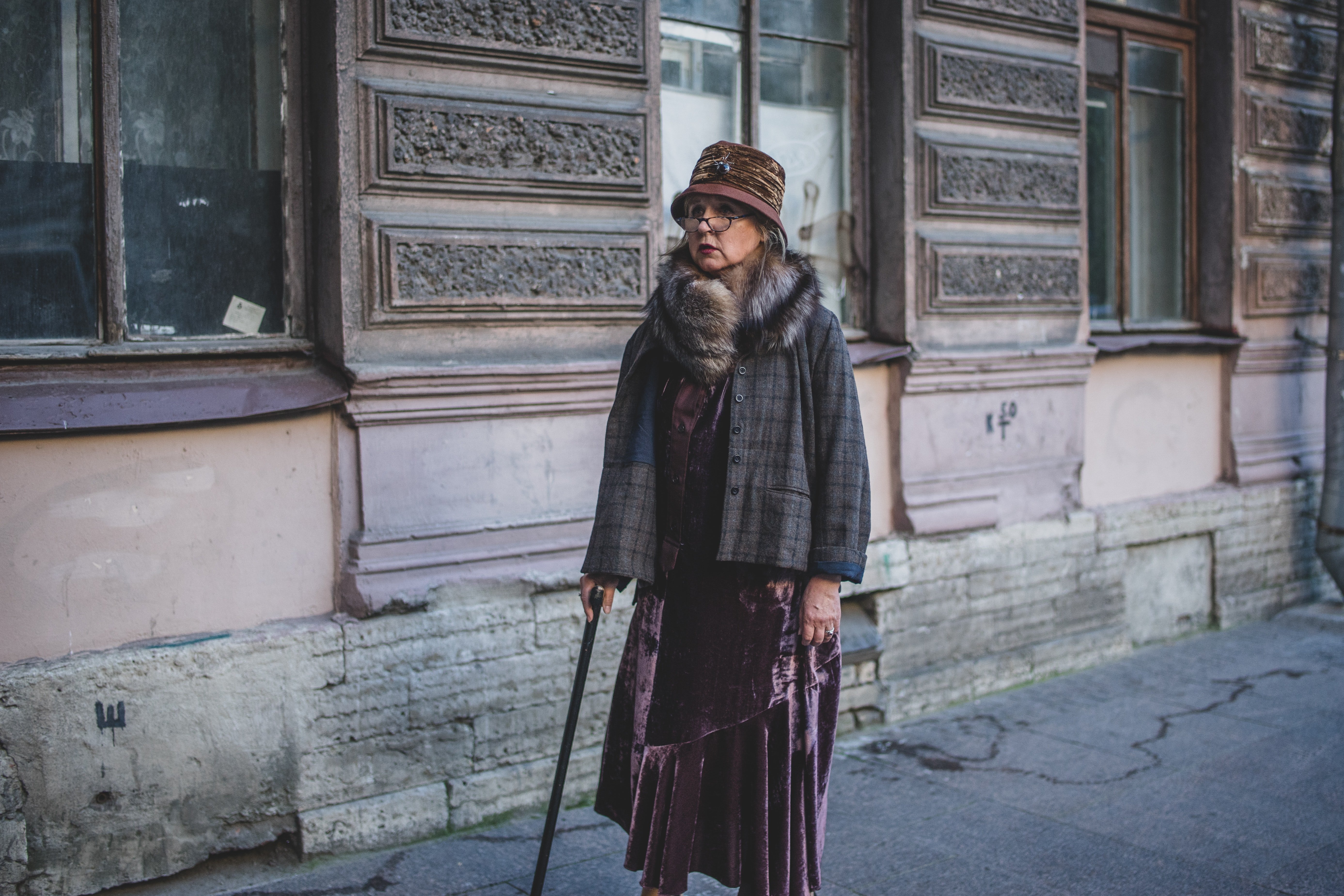 Anciana camina por la calle con abrigo y bastón. | Foto: Unsplash