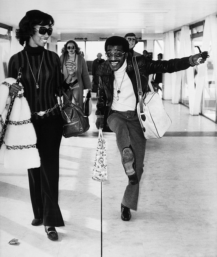 Sammy Davis Jr. dances near his wife Altovise Gore-Davis at Heathrow Airport | Photo: Getty Images