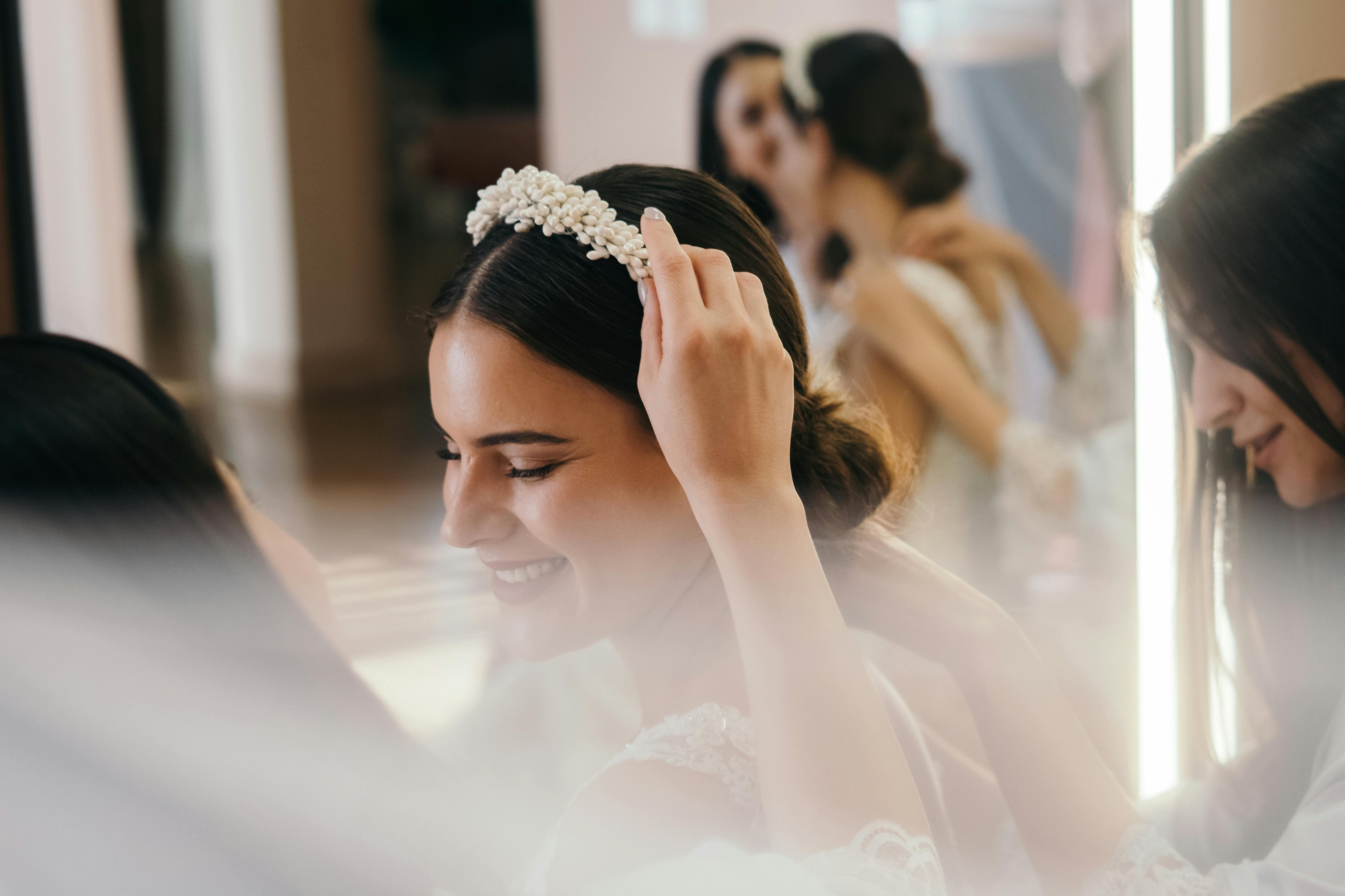 A bridesmaid putting a headband on a bride's head | Source: Pexels