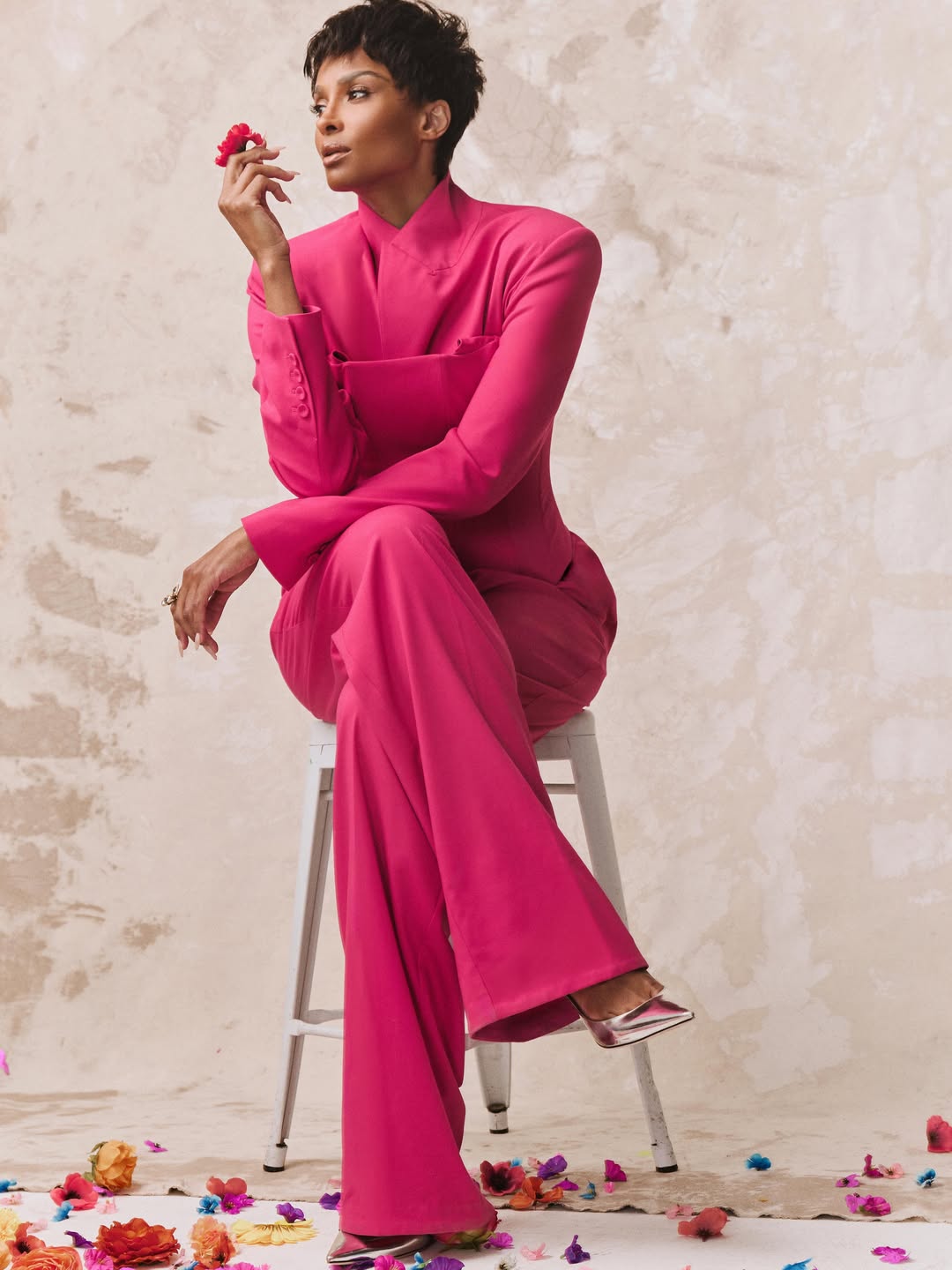 Ciara poses in a vibrant pink suit with a flower in hand | Source: Instagram/ciara