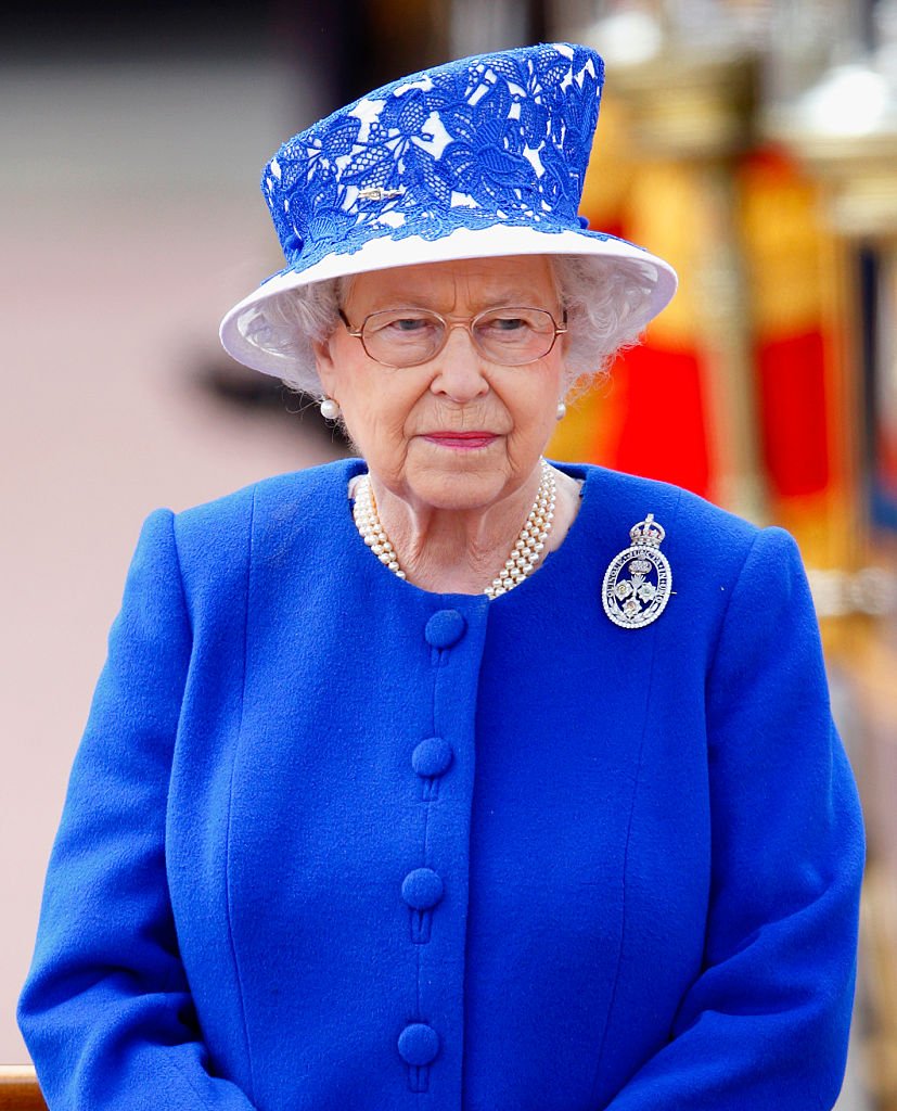 La reine Elizabeth II se tient sur une estrade à l'extérieur du palais de Buckingham lors de la cérémonie annuelle Trooping the Colour, le 15 juin 2013, à Londres, en Angleterre. | Photo : Getty Images