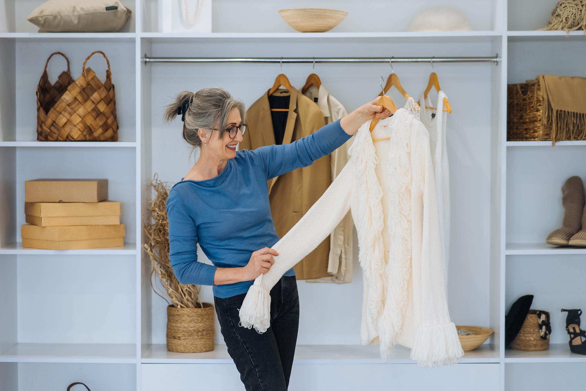 Senior woman picking an outfit from her closet | Source: Freepik