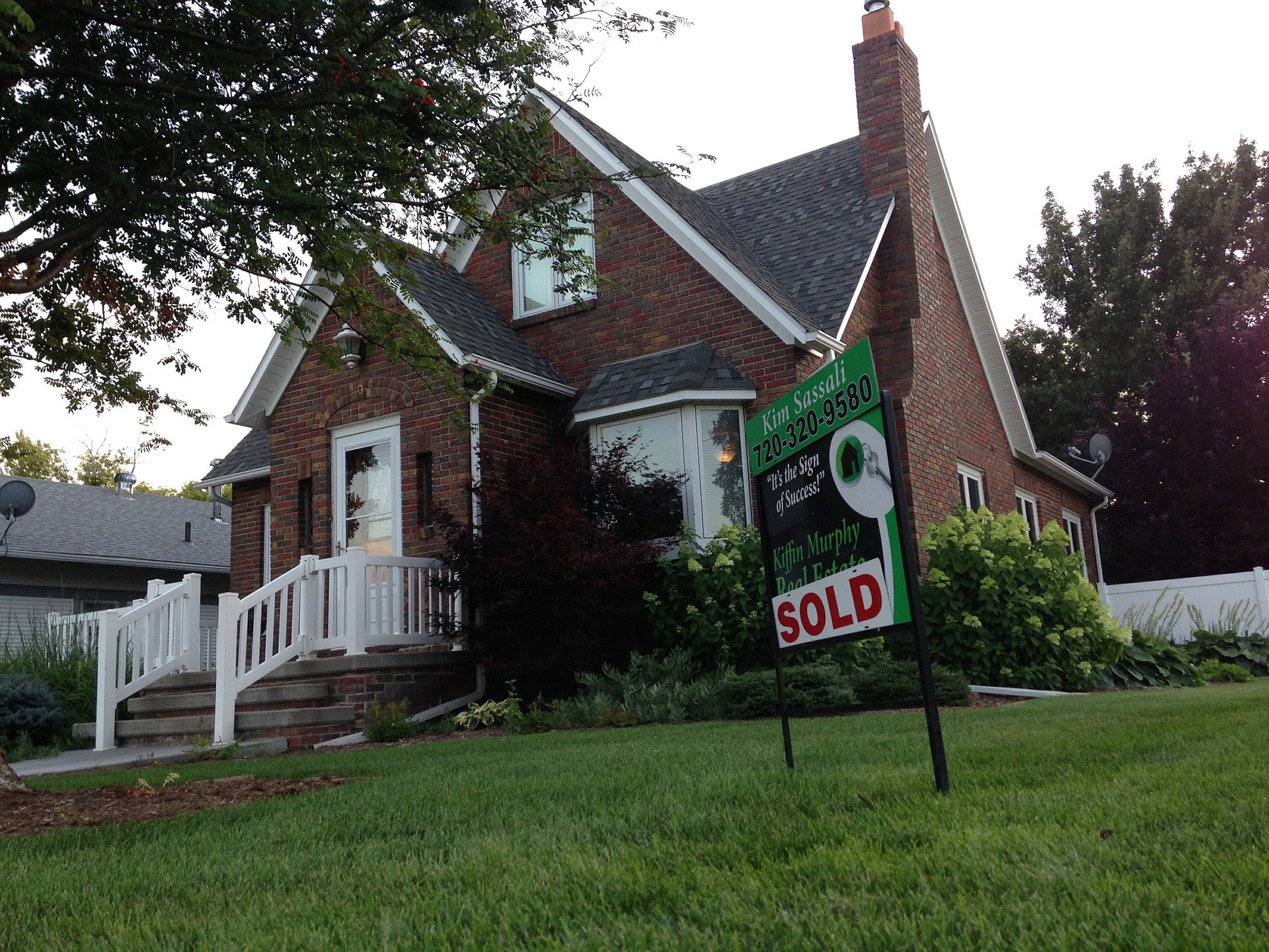 A sign on the front lawn of a house showing that it got sold. | Photo: Pixabay.