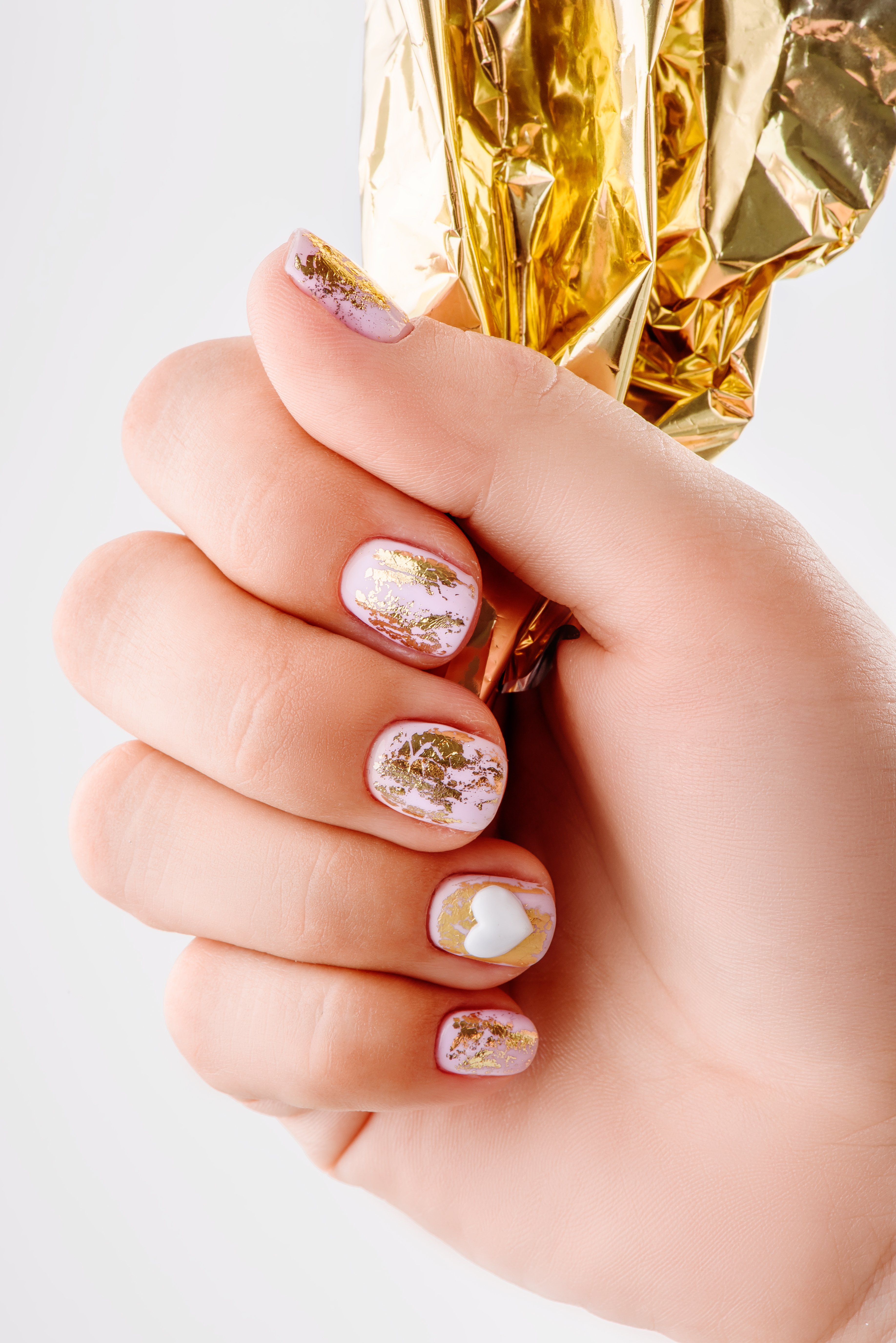 Manicured wide nails with gold nail art | Source: Shutterstock