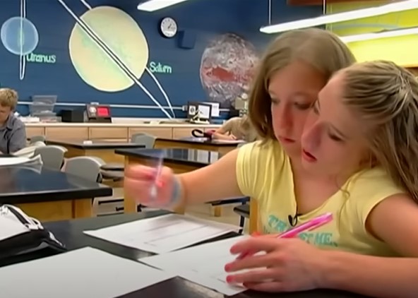 Conjoined twins Abby and Brittany Hensel attending school | Source: YouTube/Screen Static