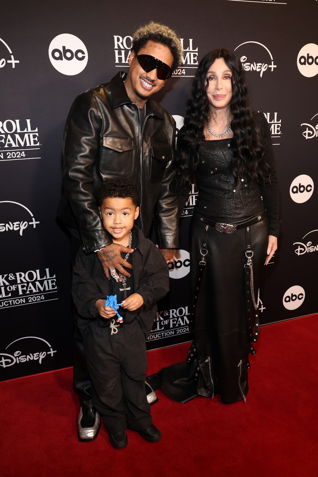 Slash Electric Alexander and Alexander "AE" Edwards with Cher at the 2024 Rock & Roll Hall of Fame Induction Ceremony on October 19 in Cleveland, Ohio. | Source: Getty Images