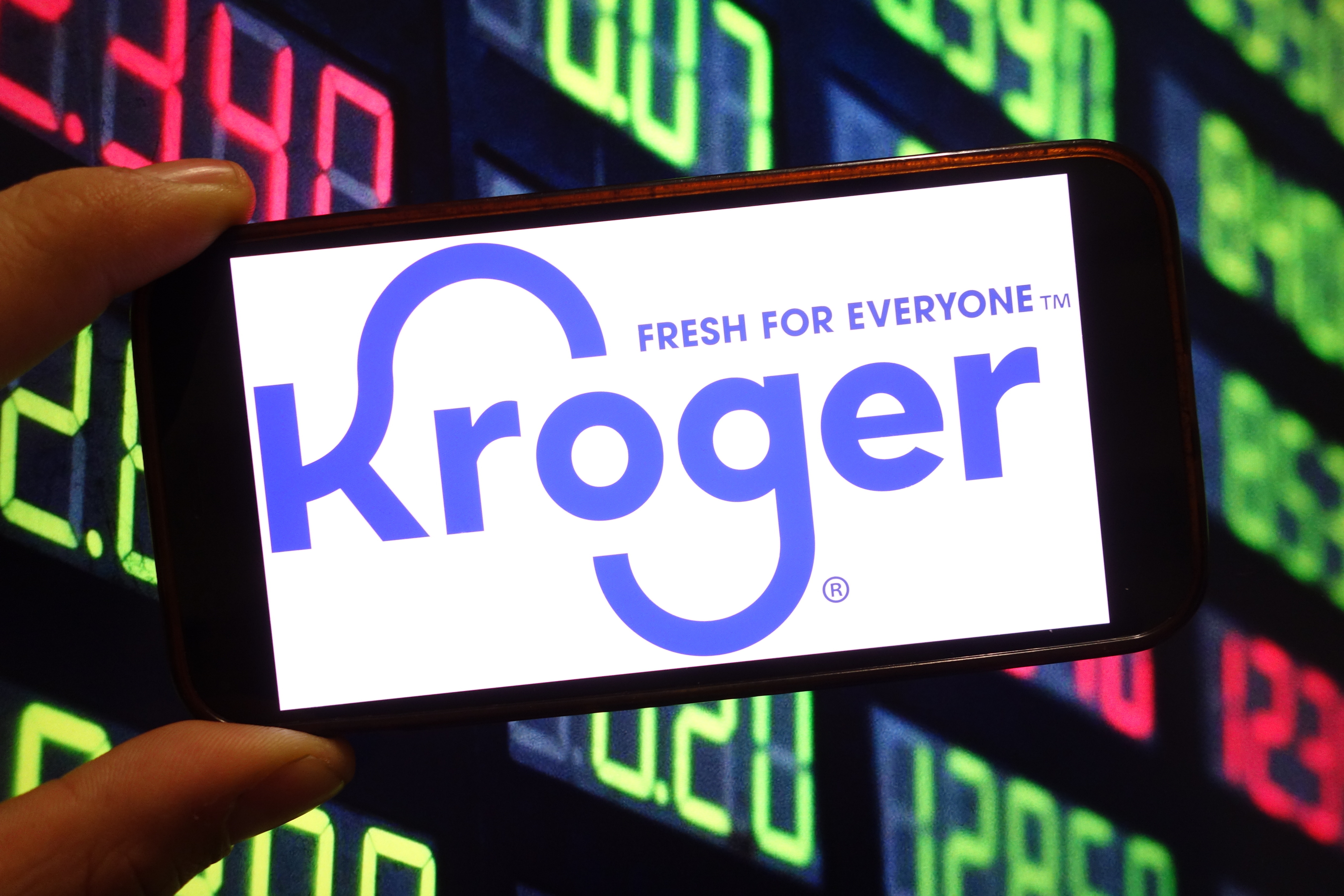 A photo of a person holding a smartphone with the Kroger logo on it taken in Poland on December 9, 2024 | Source: Getty Images