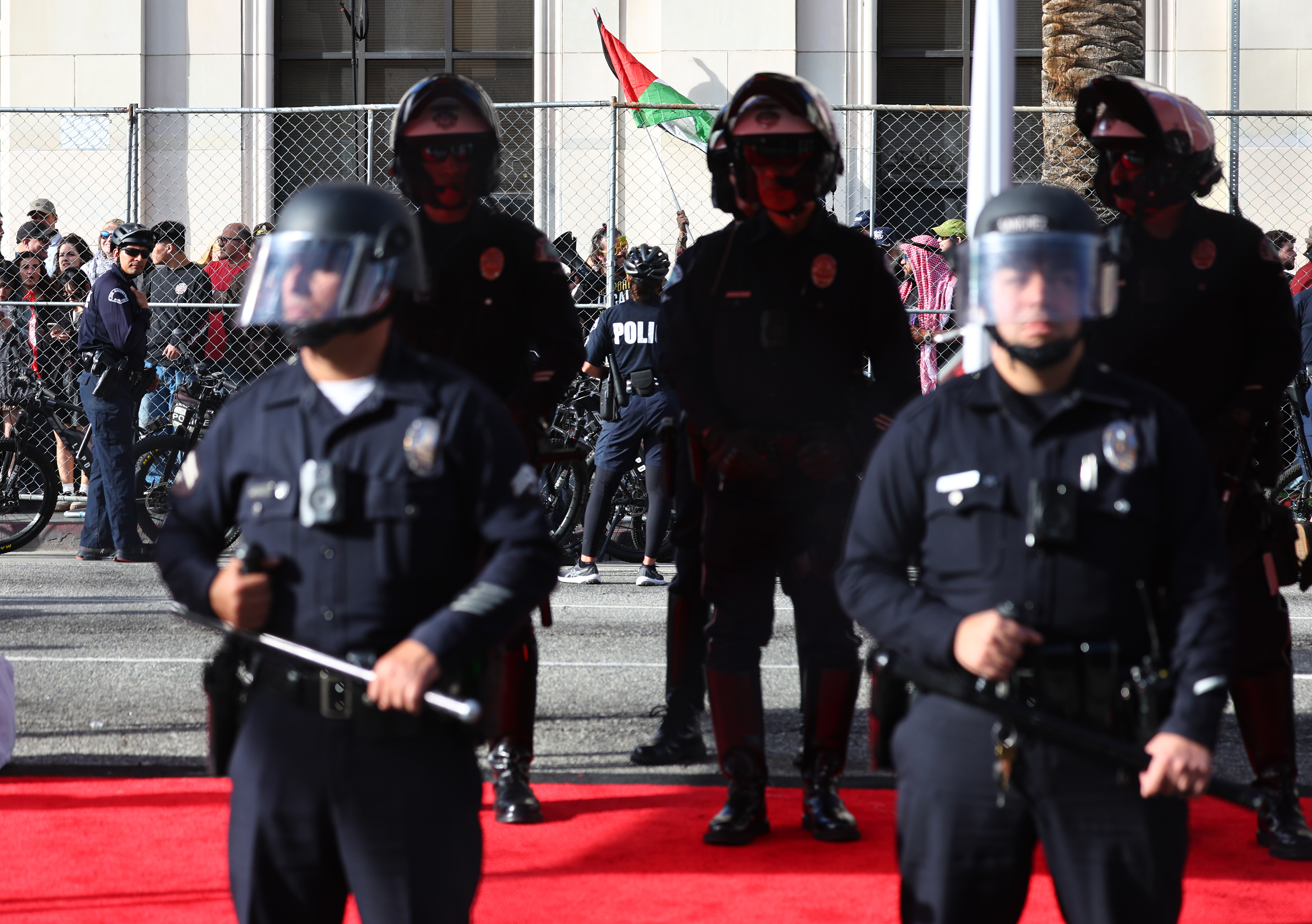 Police keep watch as a protestor waves a Palestinian flag outside the 96th Academy Awards on March 10, 2024 in Hollywood, California | Source: Getty Images