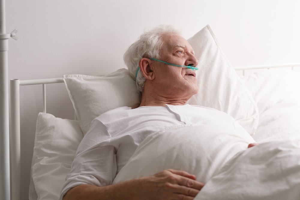 Kranker älterer sterbender Mann im Krankenhausbett, der aus dem Fenster schaut | Quelle: Shutterstock