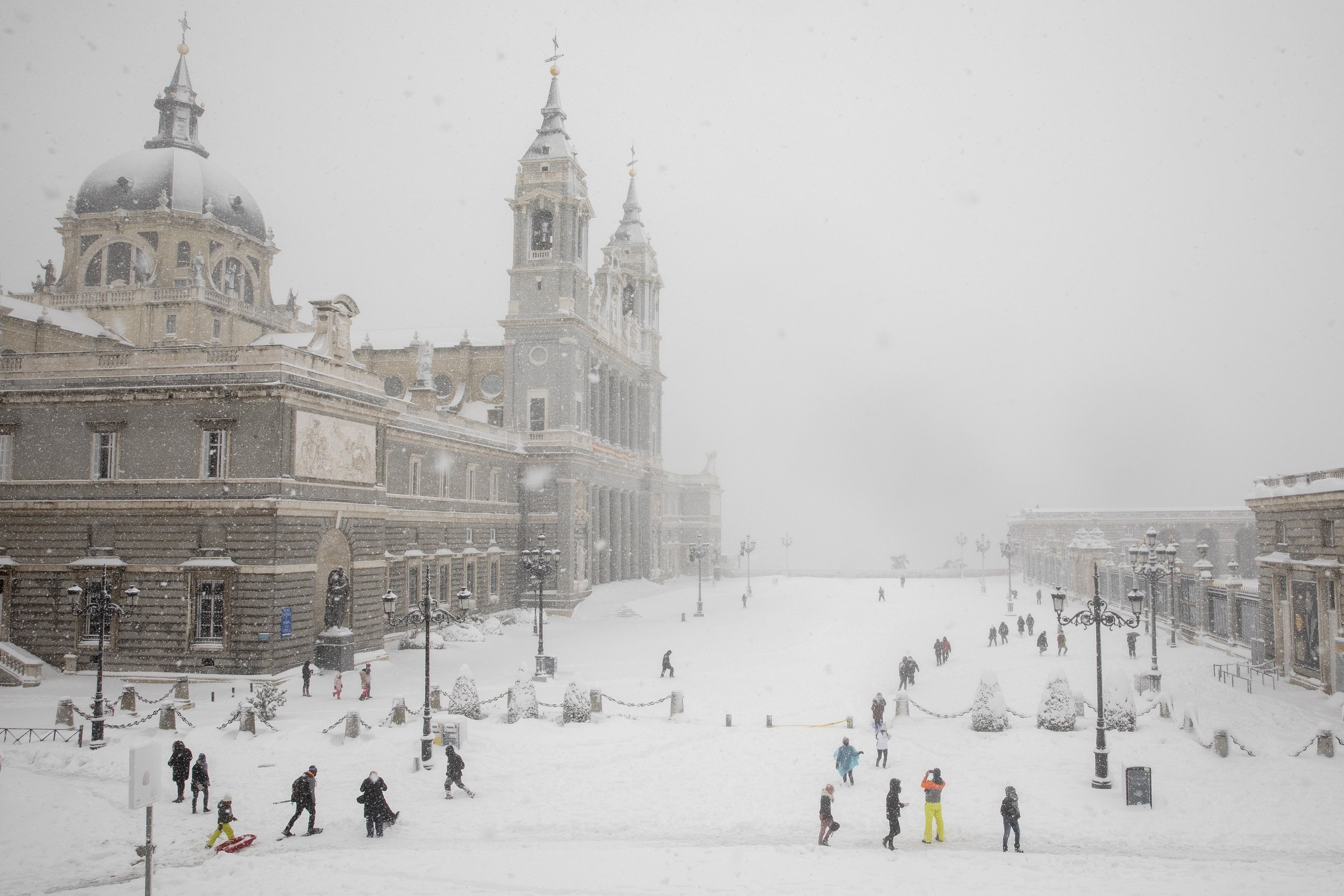 Familias atraviesan la nieve frente a la Catedral de La Almudena en Madrid en enero de 2021. | Foto: Getty Images