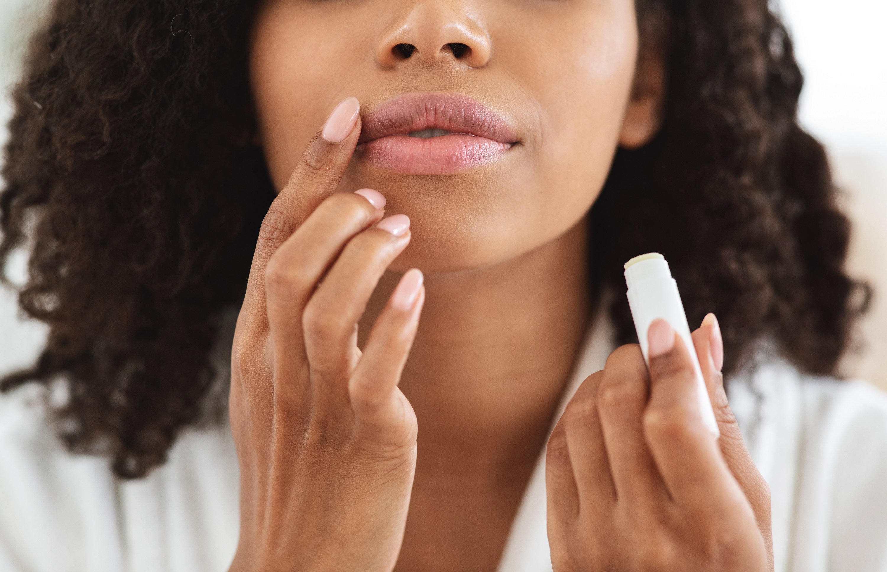 Mujer aplicando producto a sus labios. | Foto: Shutterstock