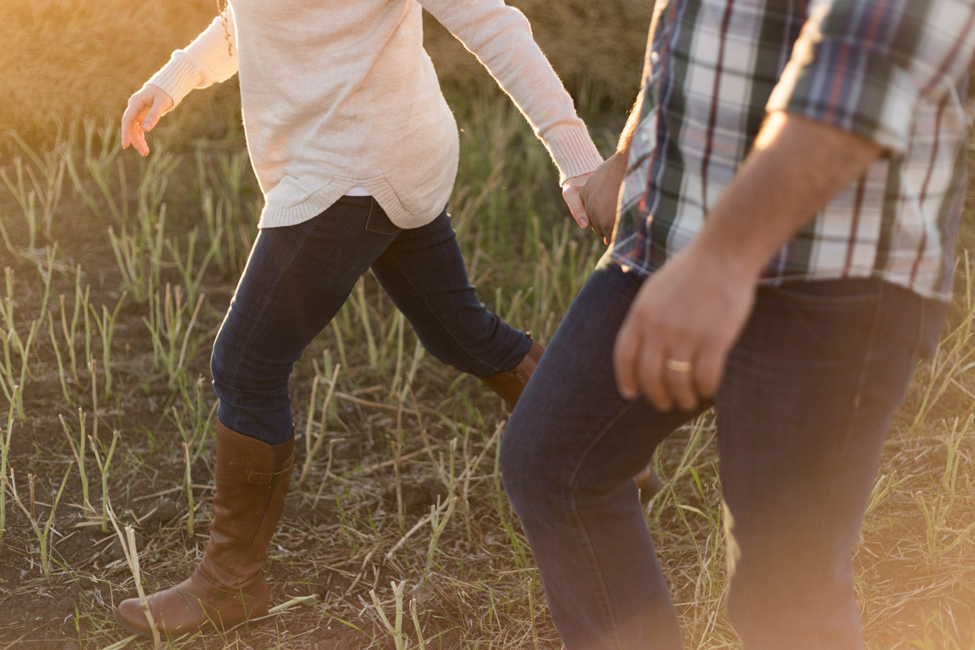 A couple holding hands in a field | Source: Unsplash