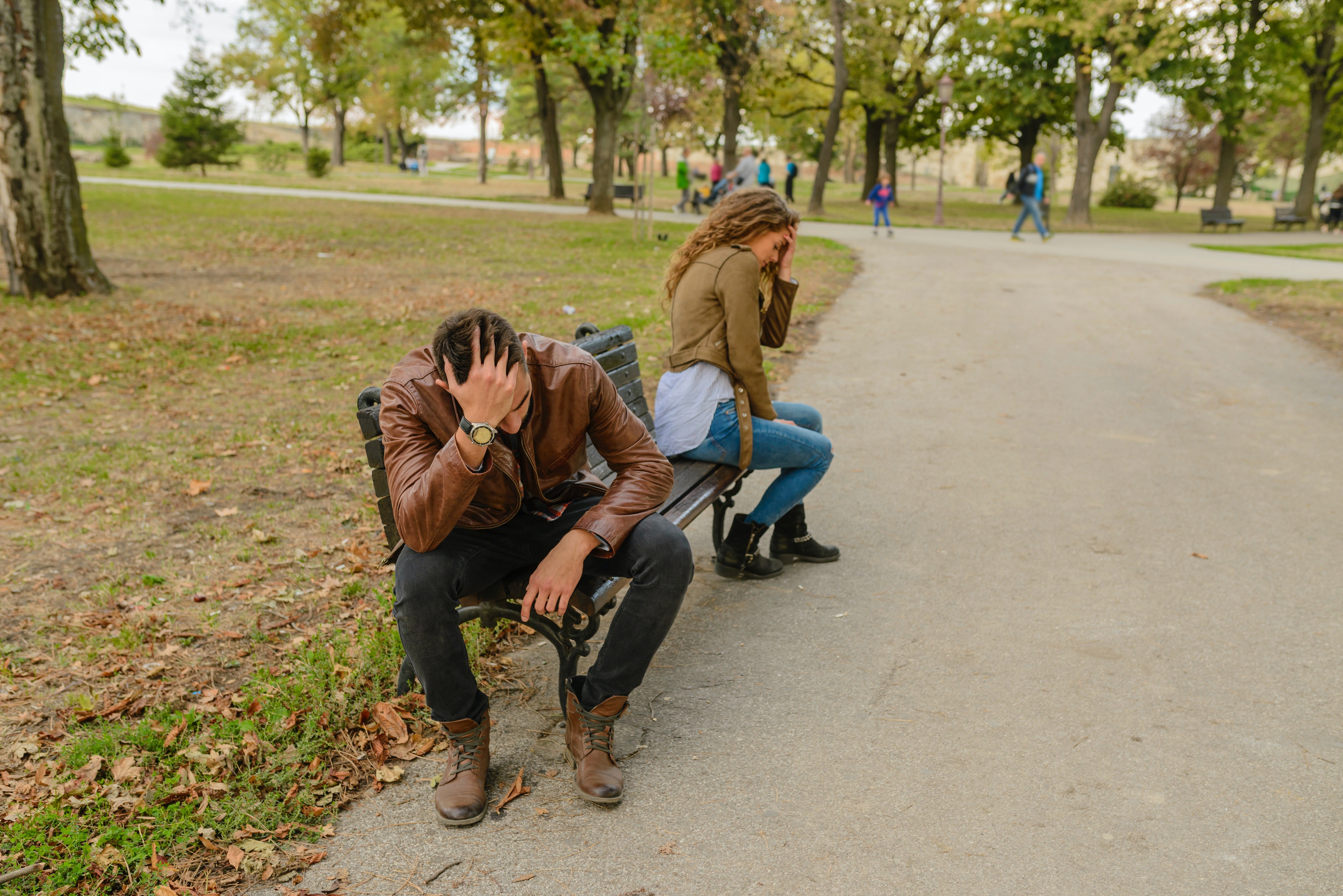 Upset and exhausted over a heated argument, couple sit apart on a bench | Photo: Pexels/vera-arsic